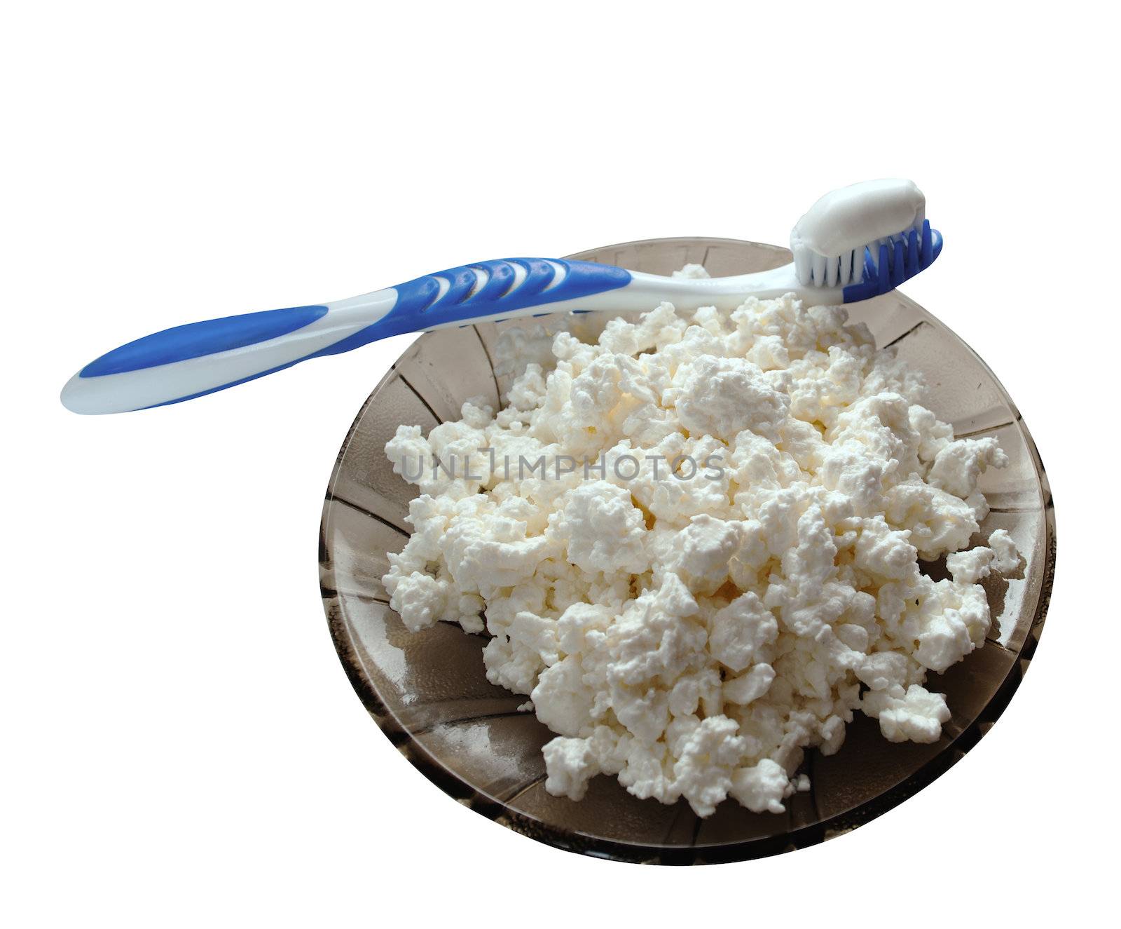 toothbrush, edged massaging bristles made of soft rubber with toothpaste is on a saucer with curds