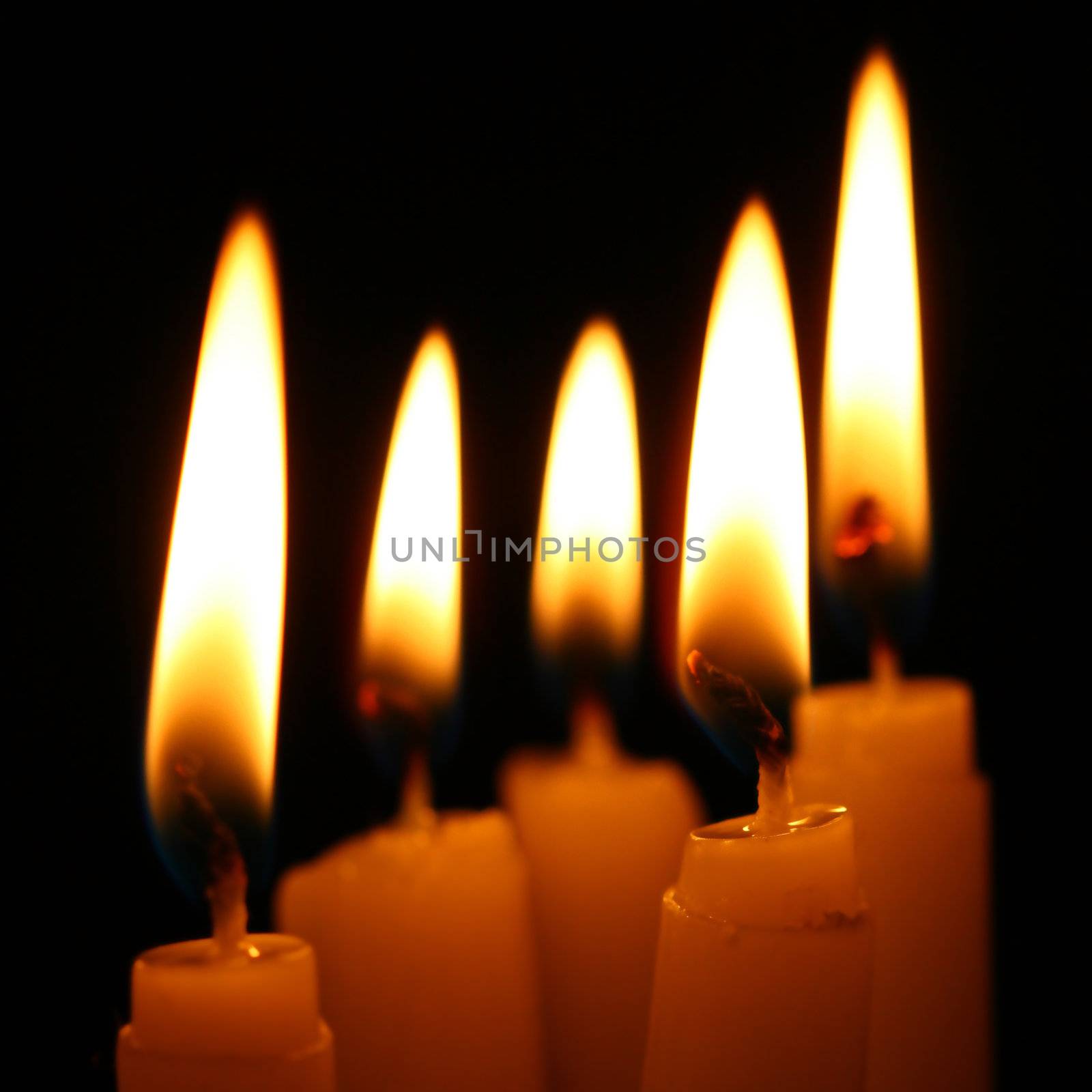 sacred candles in dark on black background