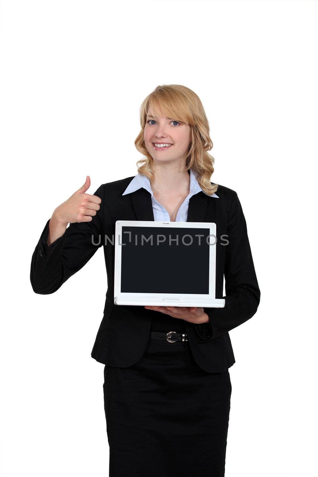 Businesswoman holding a laptop and giving the thumb's up by phovoir