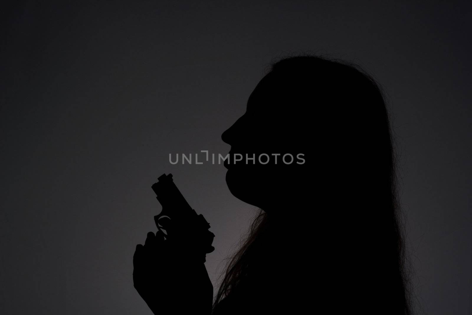 Woman with gun in the darkness