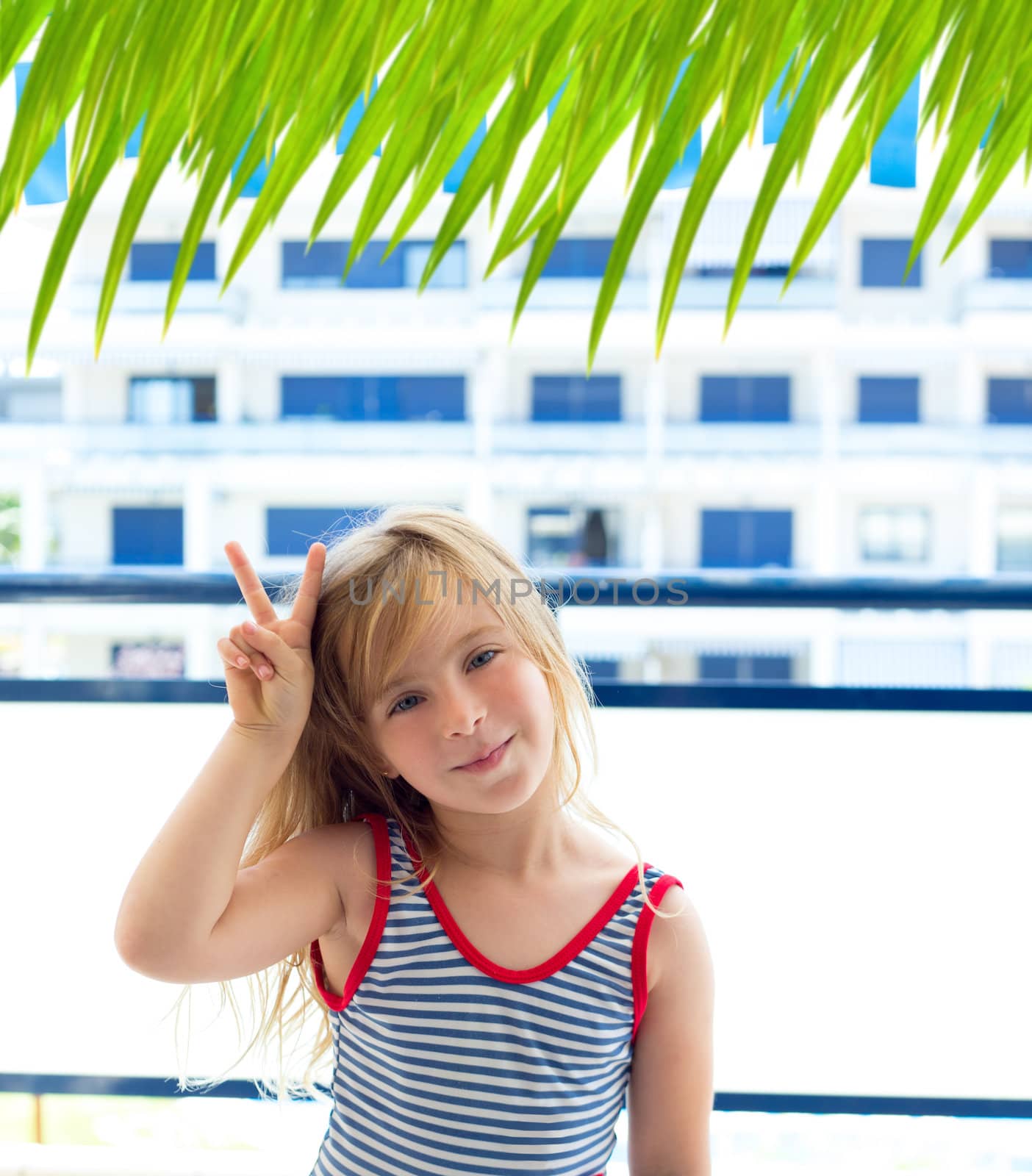 Blond kid girl with summer swimsuit with hands victory sign smiling