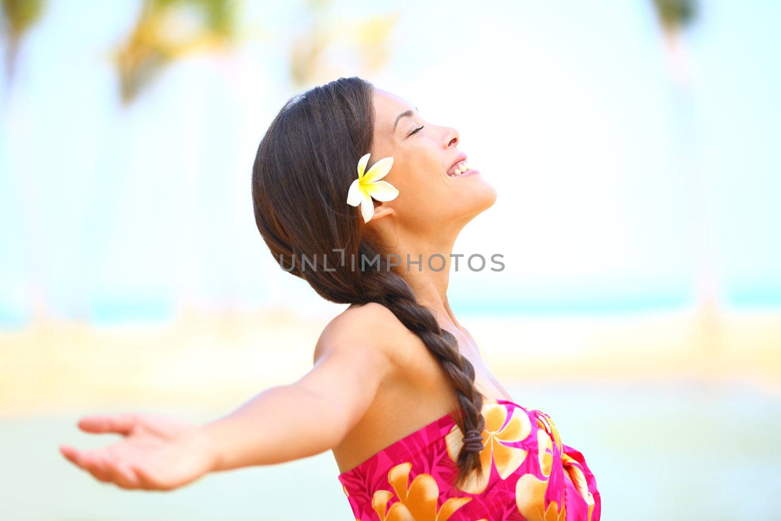 Freedom beach woman smiling happy and serene with arms outstretched in free pose. Beautiful spiritual elated happiness concept image with multicultural Asian / Caucasian female model.