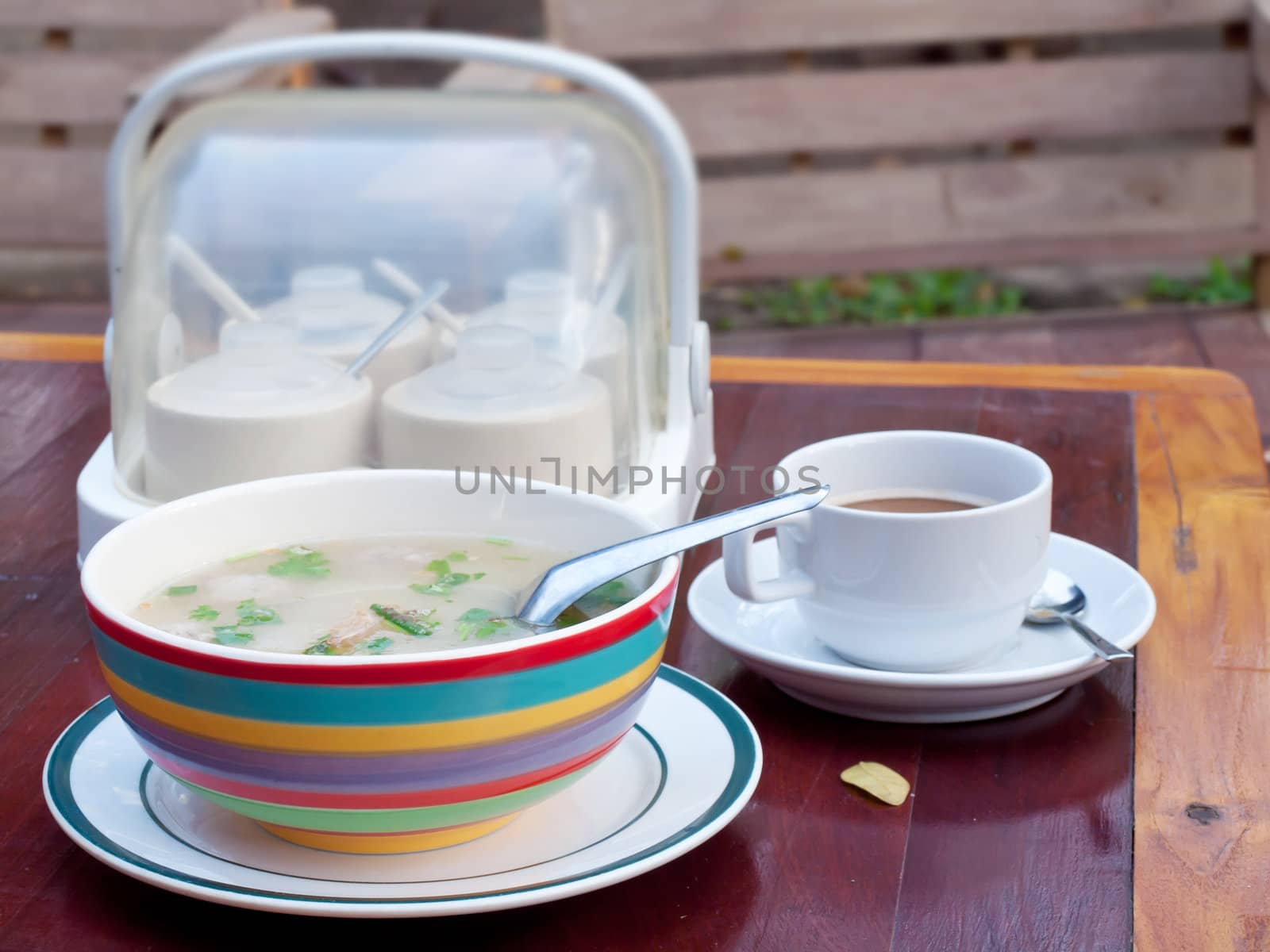 Thai style breakfast soft boiled rice mixed with ground pork, seasoning unit and coffee