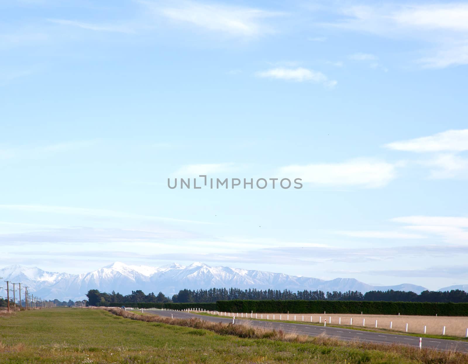 Long road stretching out into the distance with snow mountain background in New Zealand