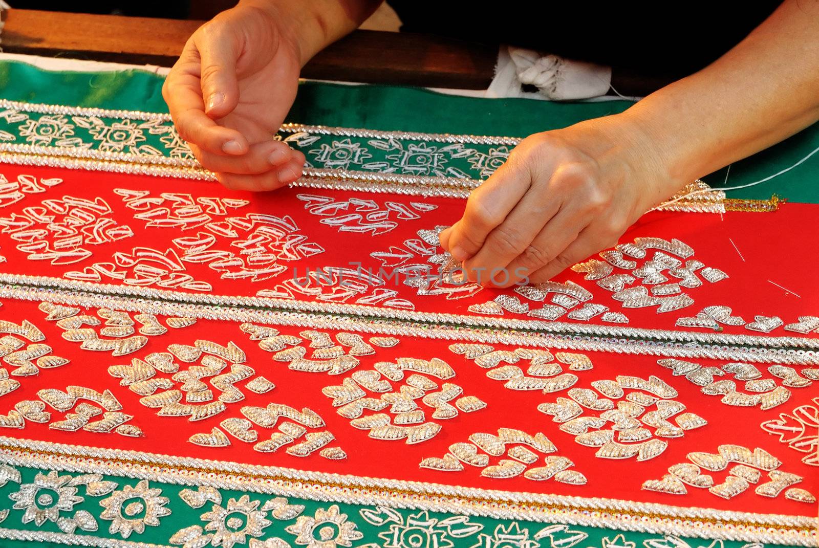 Female Hand stitching cloth to make ancient Thai pattern fabric 