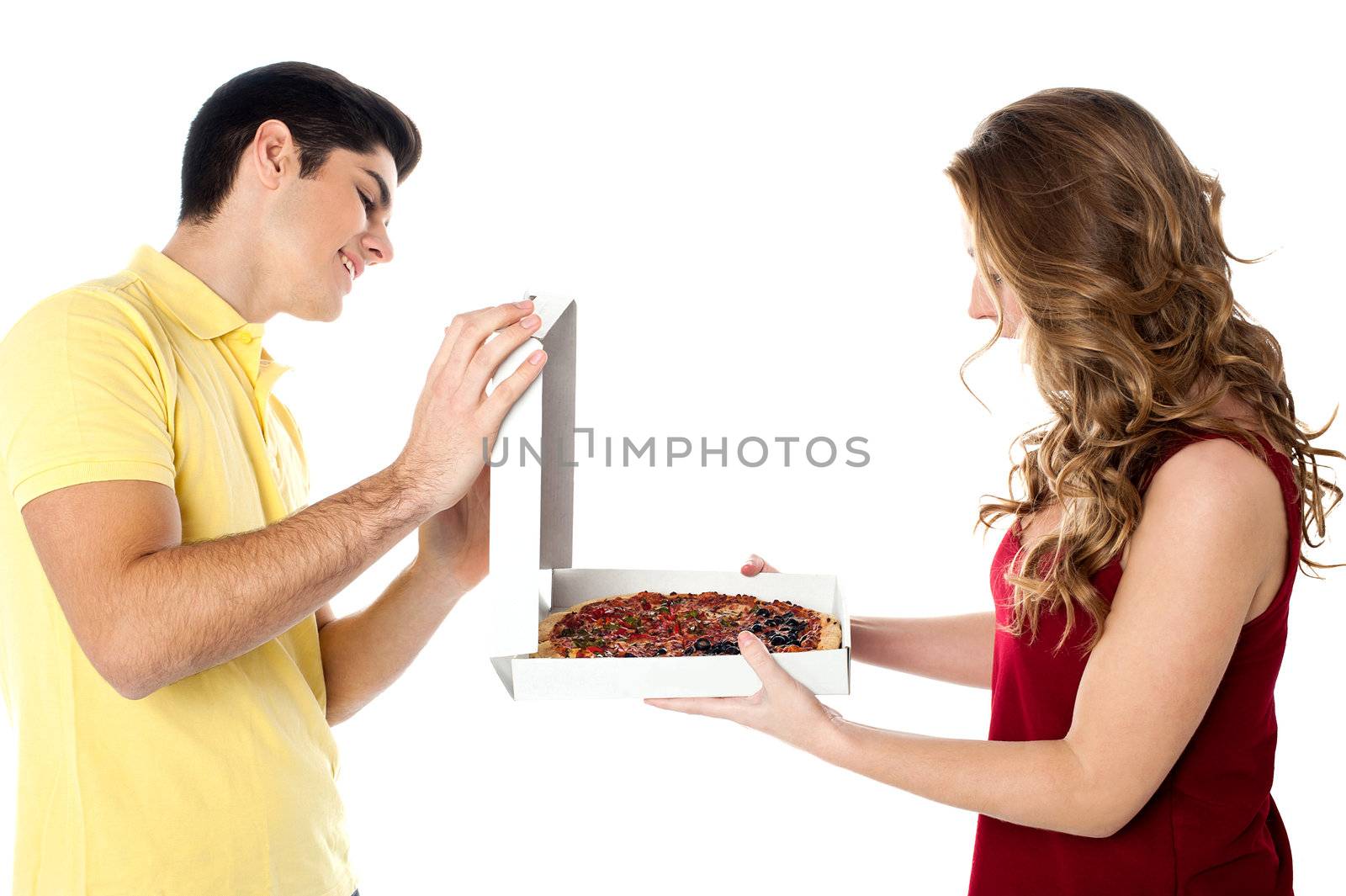 Affectionate young man presenting his lover a hot pizza.