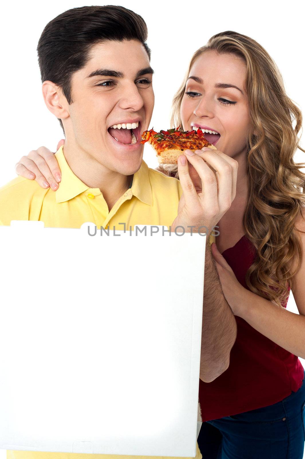 Hungry young couple relishing a slice of pizza.