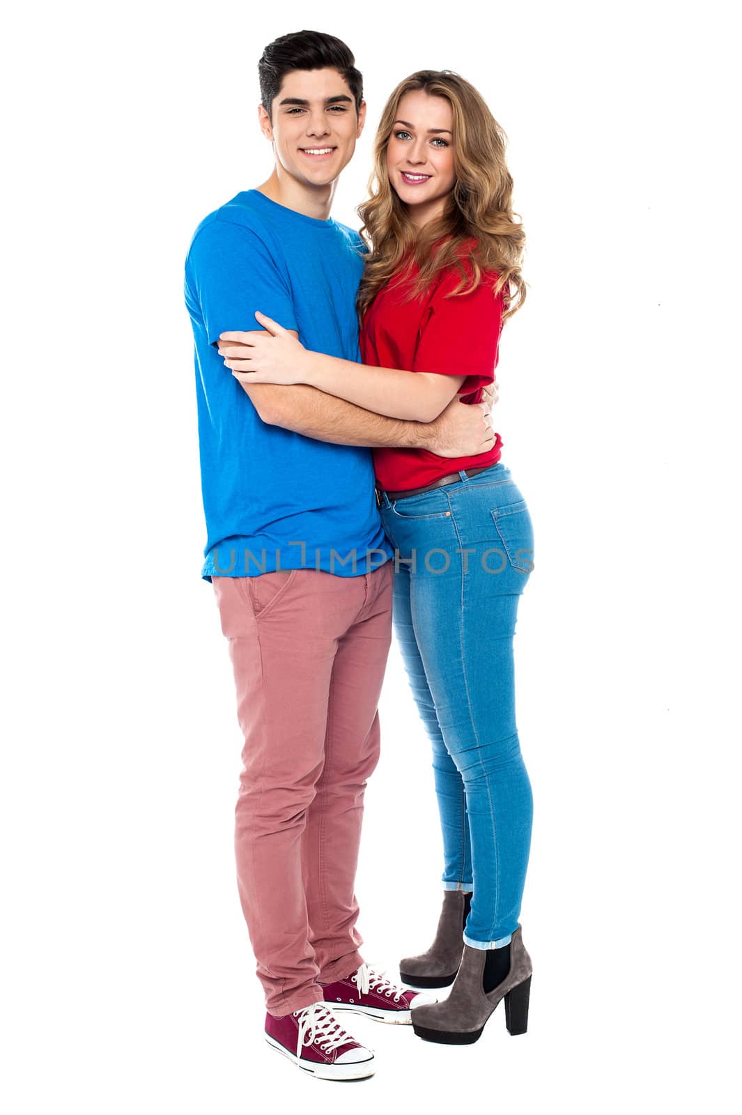 Full length portrait of a couple in casuals hugging each other.