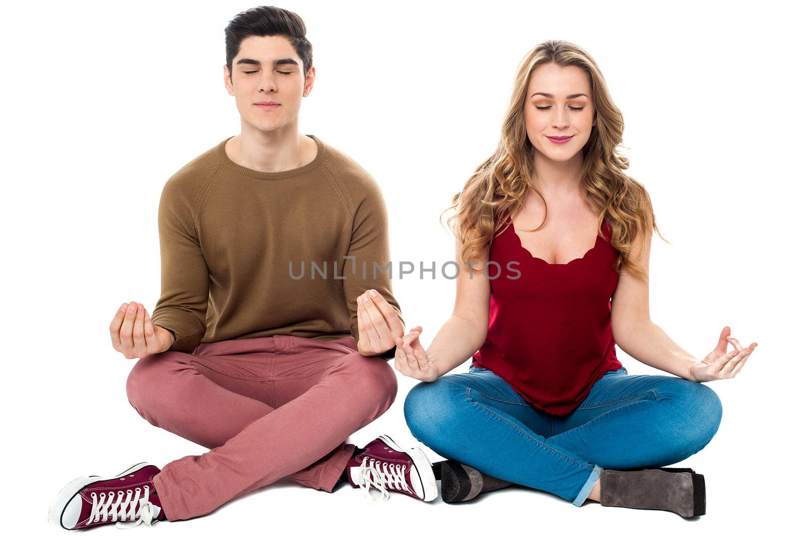 Young man and woman on white background meditating peacefully.