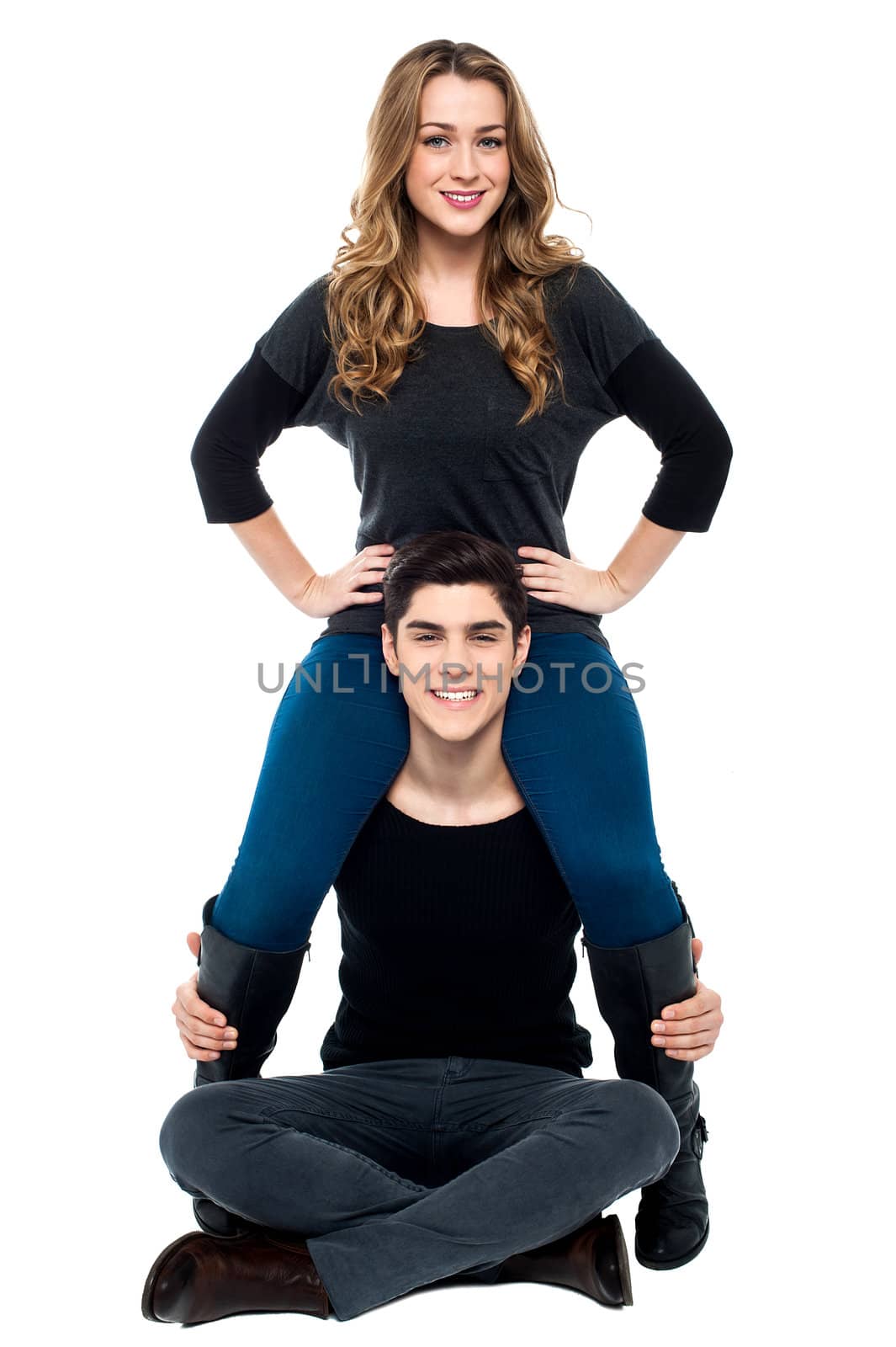 Cool young boy sitting on the floor with girlfriend on his shoulders.