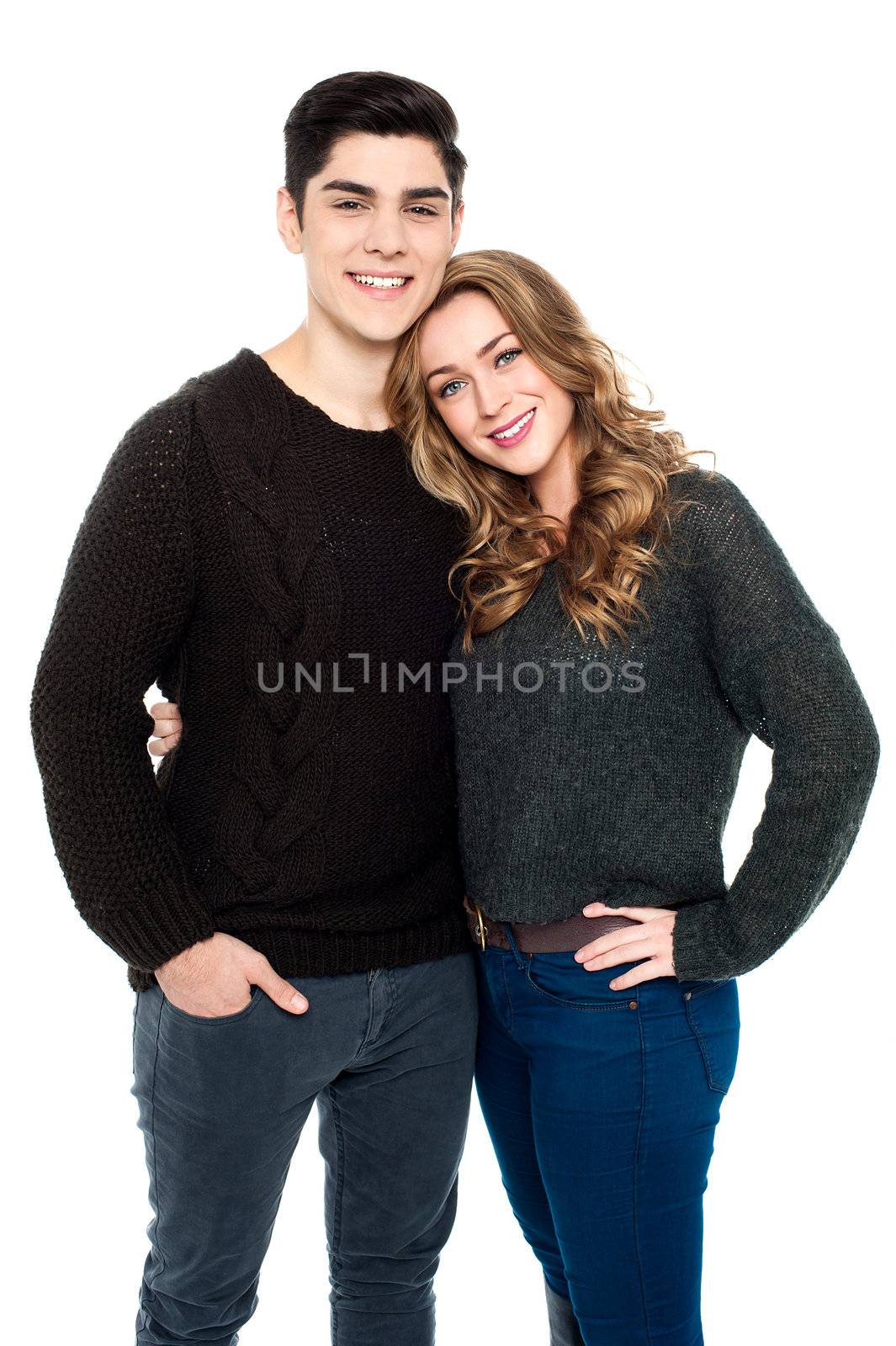 Fashionable young couple in warm clothing embracing each other.