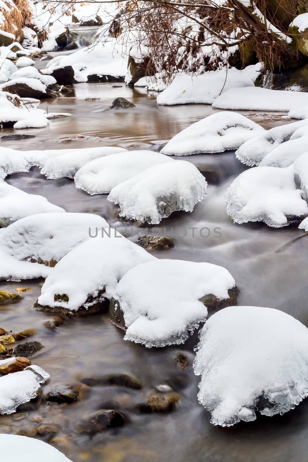 Falls on the small mountain river in a wood shooted in winter