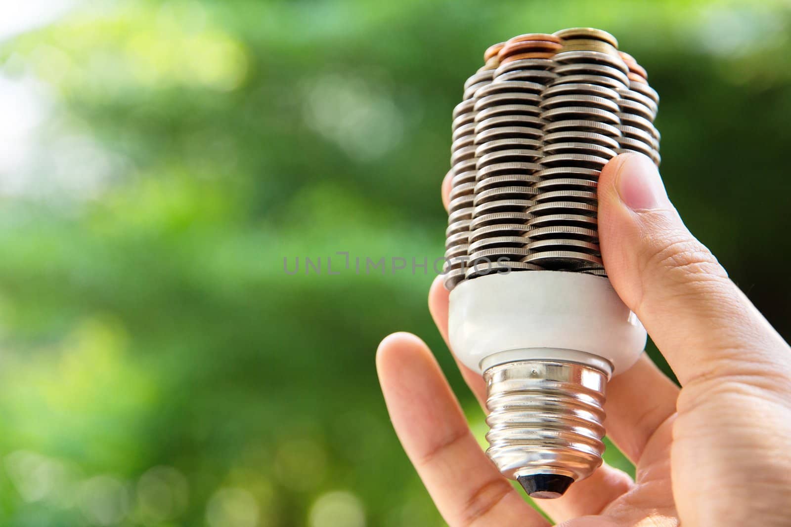 hand holding coin light bulb,energy concept by ponsulak