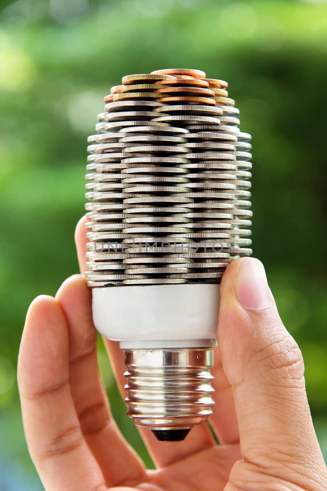 hand holding coin light bulb,energy concept