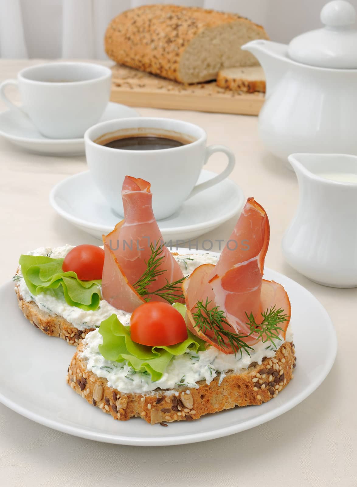 breakfast with a cup of coffee and a sandwich of whole grain bread with ricotta and ham