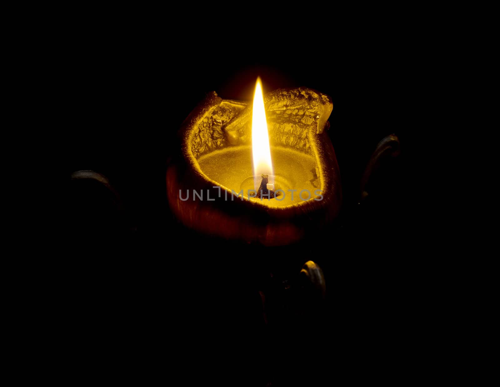 a burning black candle on a black background.