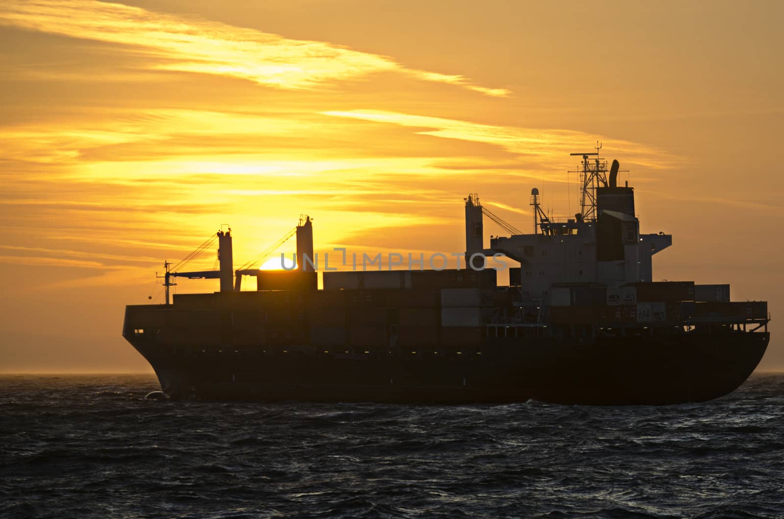 A container ship heading towards sunset on the german North Sea.