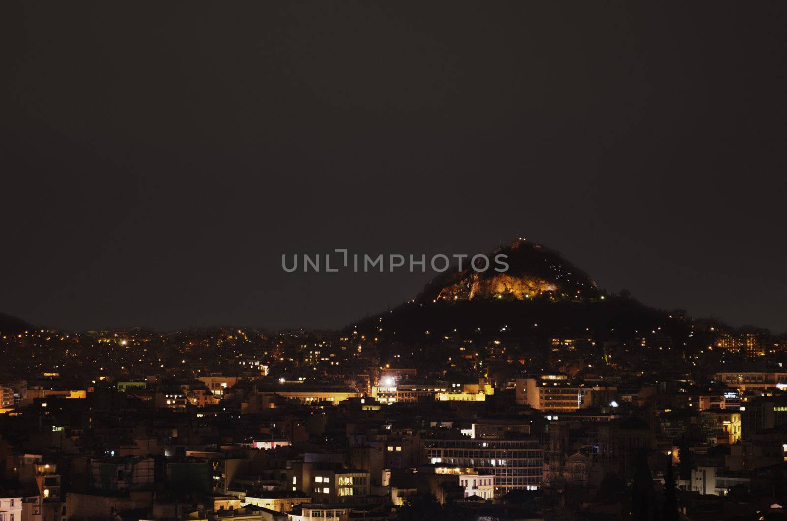 Nighttime view over Athens. The Lykavittos can be seen as a prominent feature in the picture.