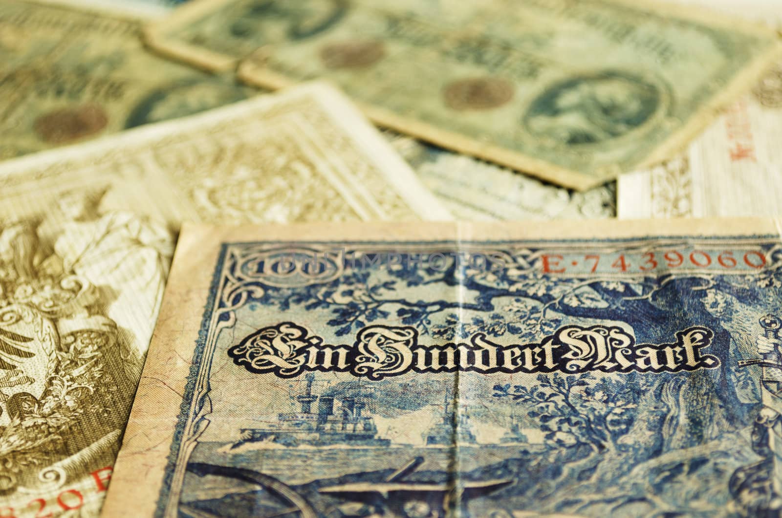 Part of an old German banknote from 1908. Other old banknotes can be seen blurred in the background.