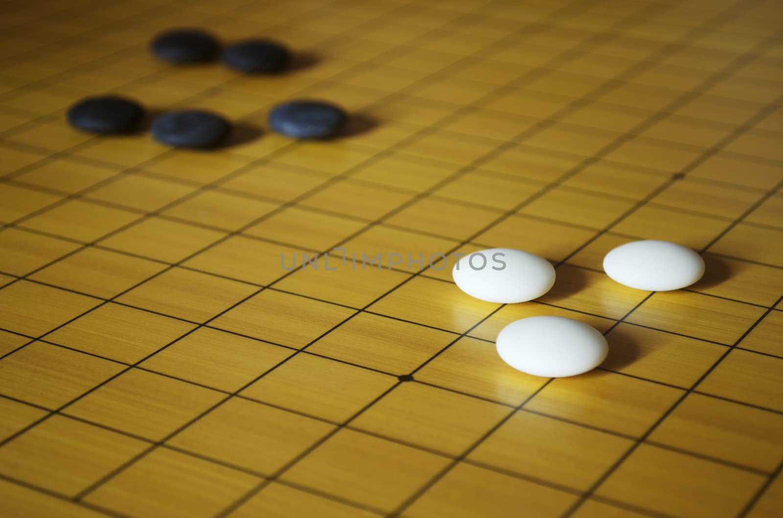 Close up shot of a goban with stones. Go is a traditional Asian board game. Shallow depth of field.