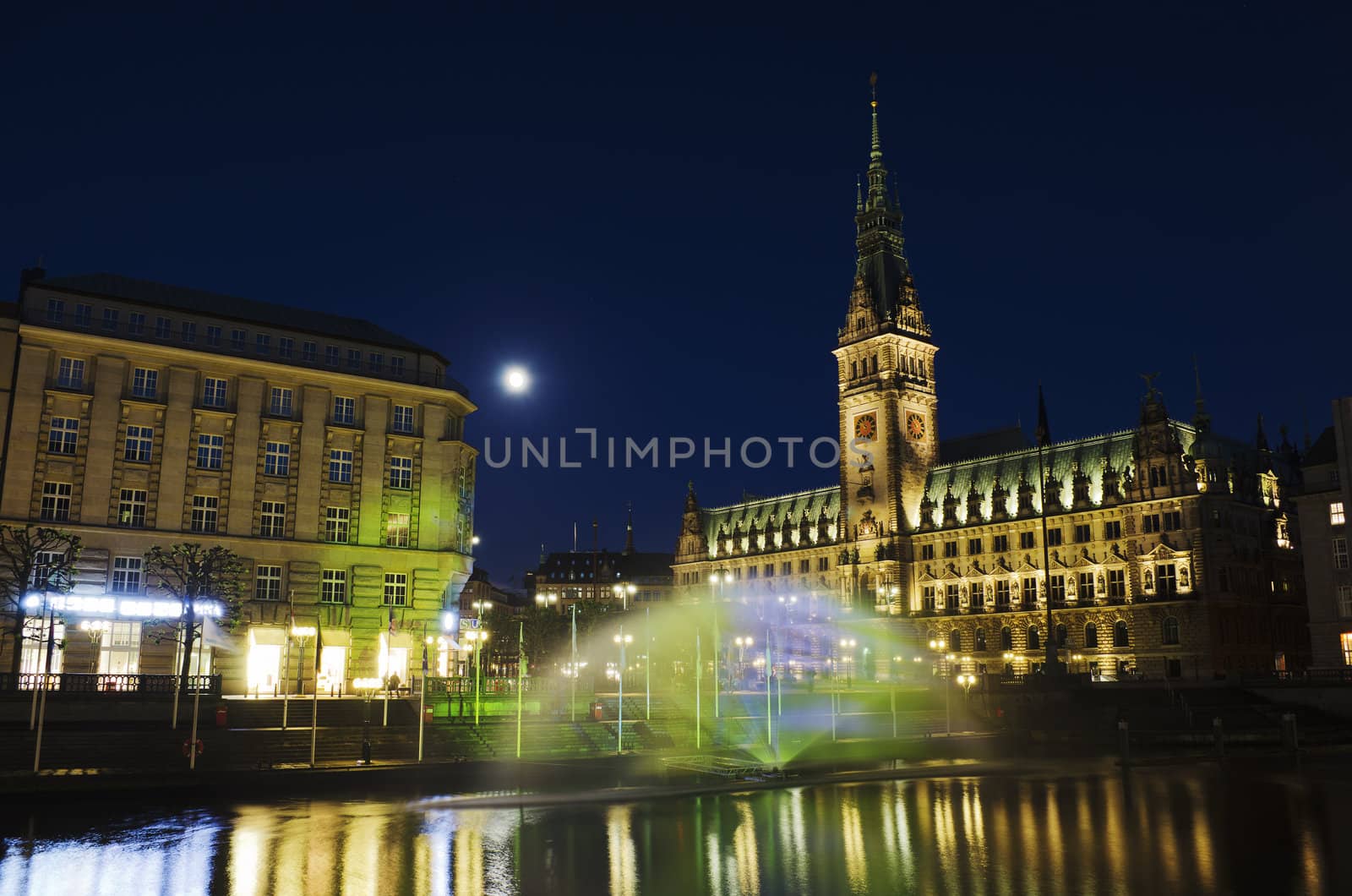 A colorful lighted fountain on the Alster in front of the town hall of Hamburg.