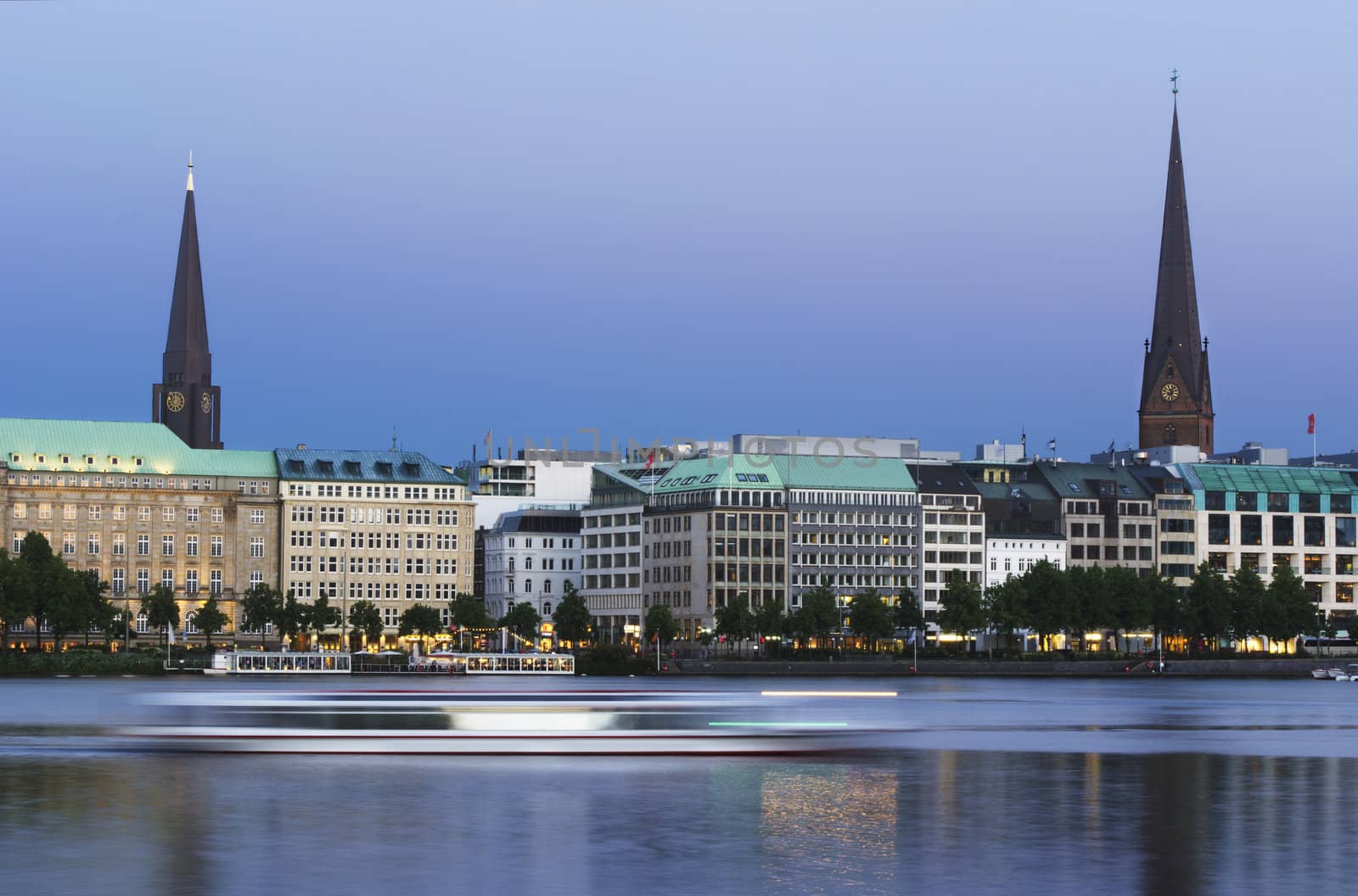 Long exposure evening shot of the Binnenalster in Hamburg. A ferry is blurred by its motion.