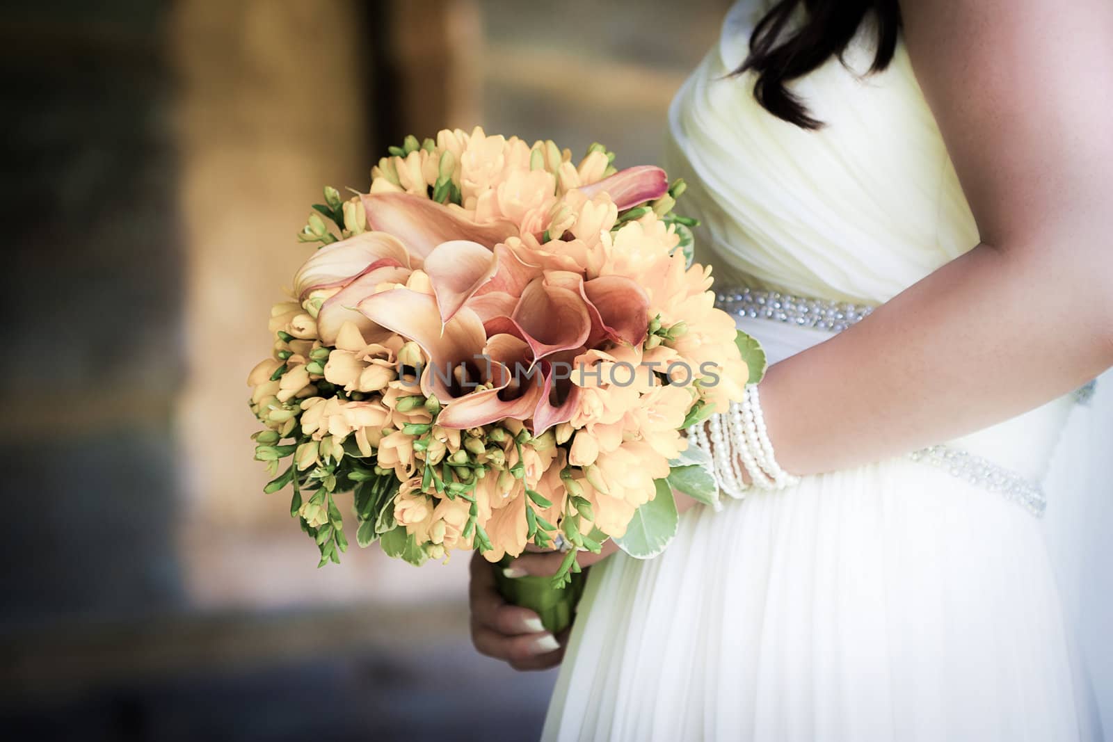 Bride holding a wedding bouquet by PixAchi