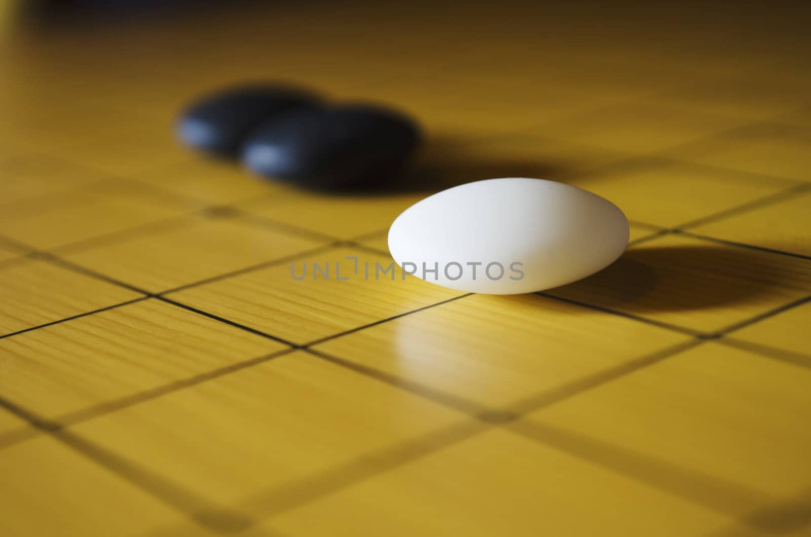 Close up shot of three go stones. Go is an ancient traditional Asian board game. Shallow depth of field.