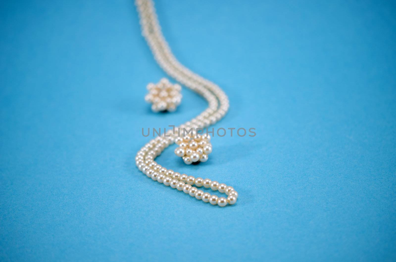 pearl jewelry beads necklace earring decoration on blue background.