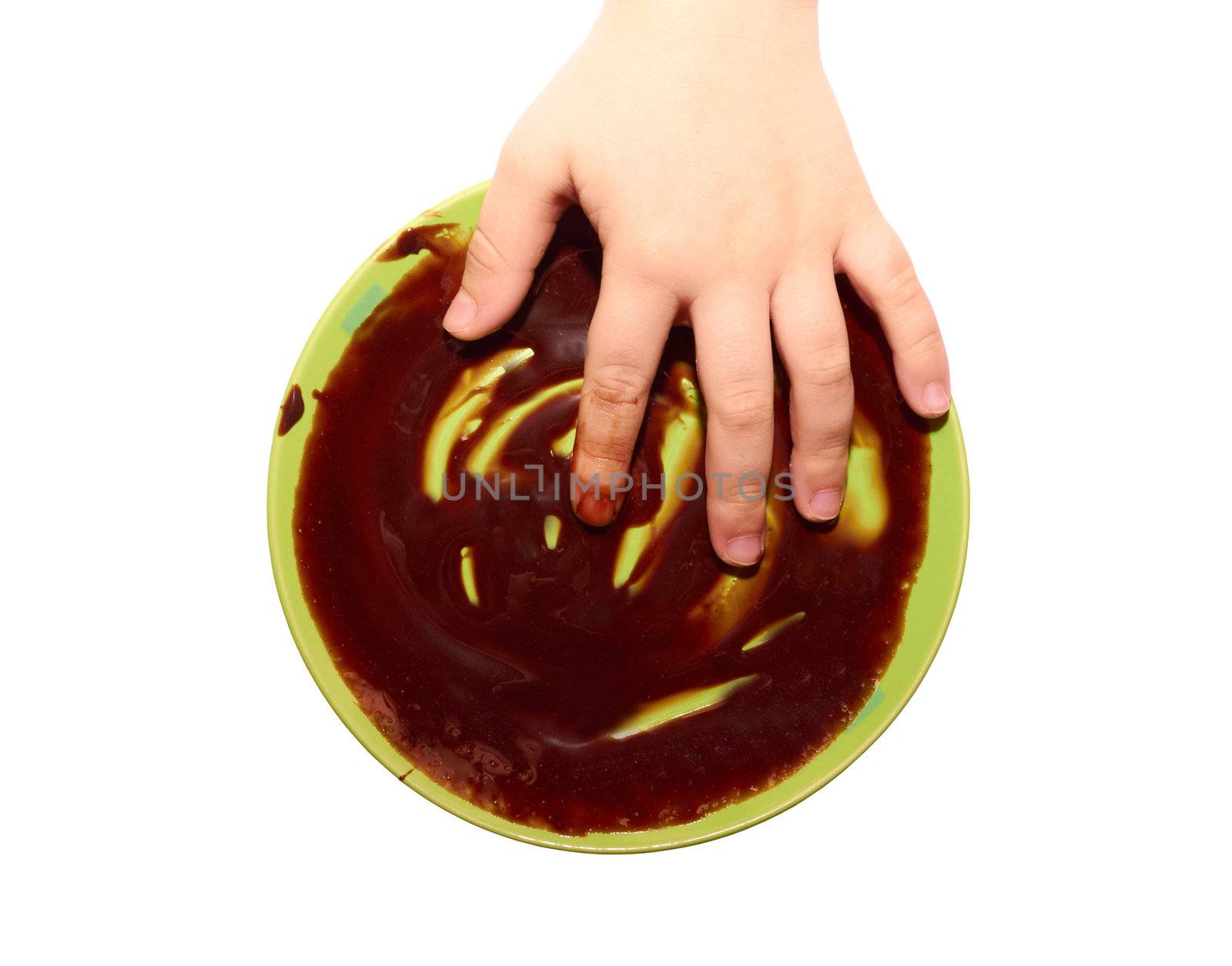 A small child's hand in a bowl of chocolate isolated on white background