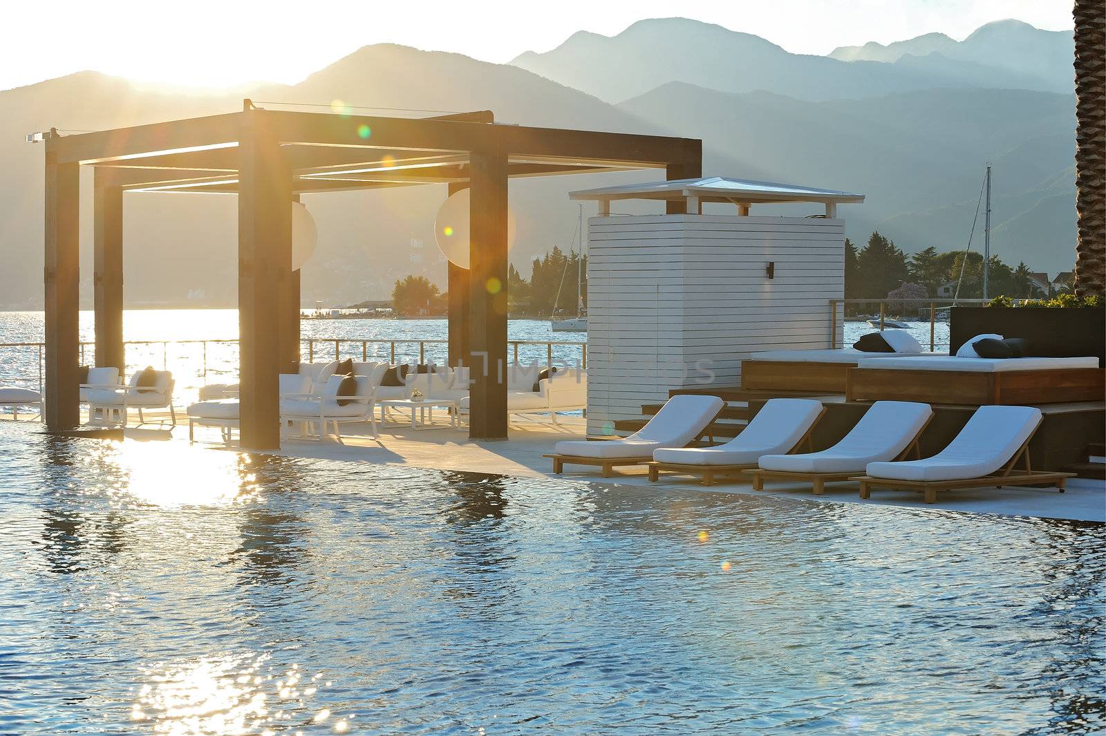 Sunset over mountains and infinity pool