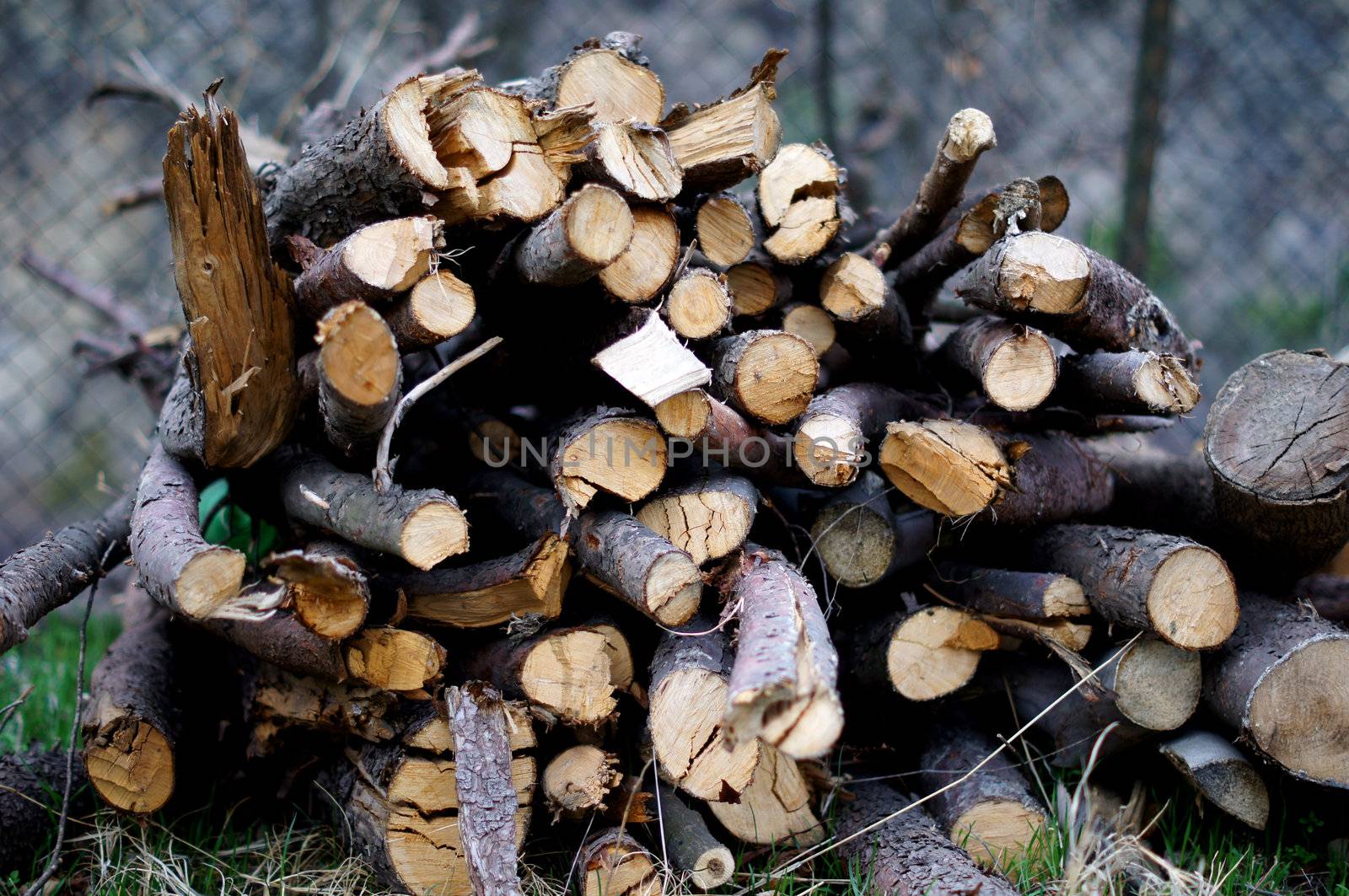 Background of dry chopped firewood logs stacked up on top of each other in a pile