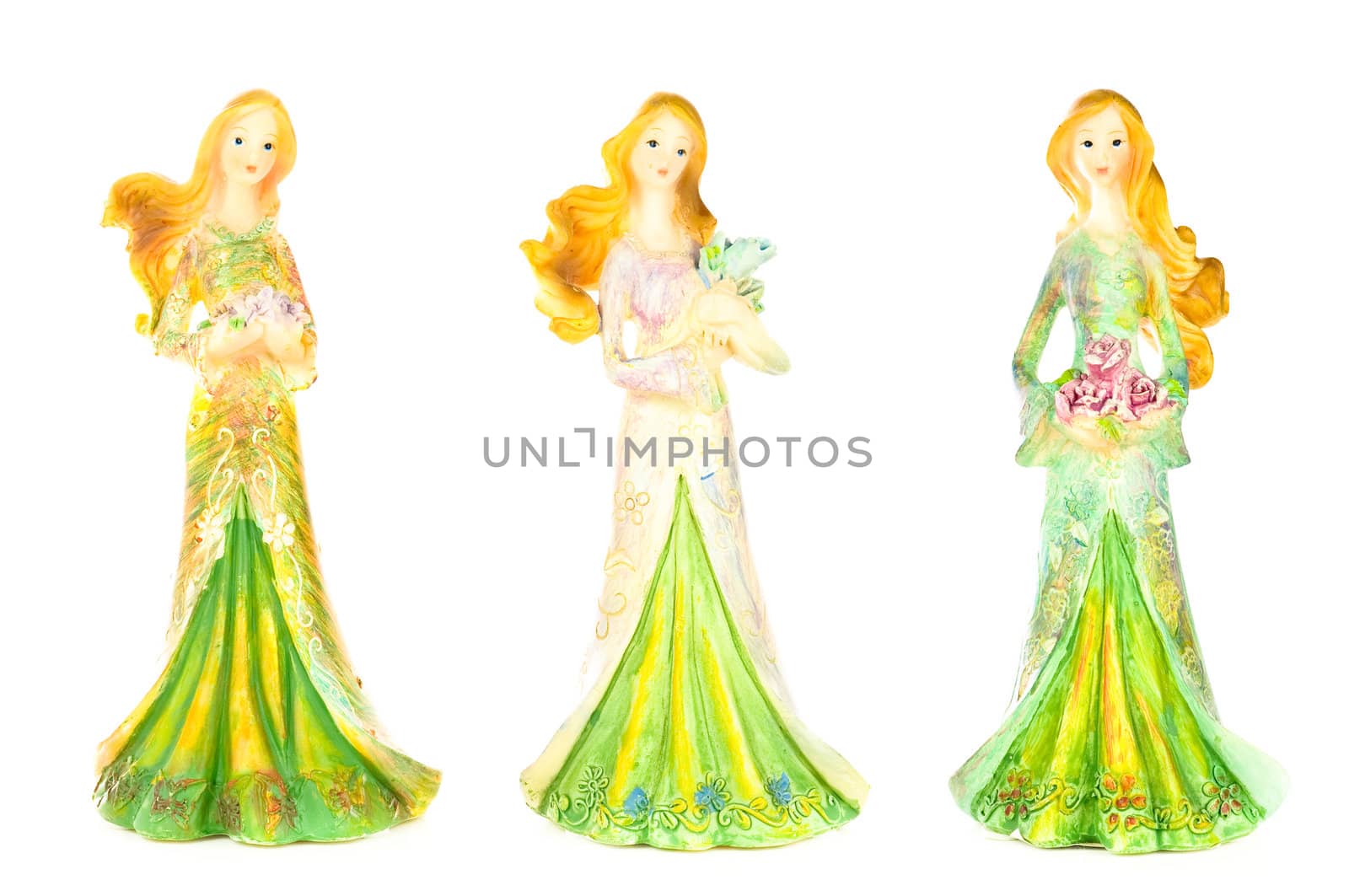 Three pretty lady statues all dressed up and holding flowers; isolated on white background.