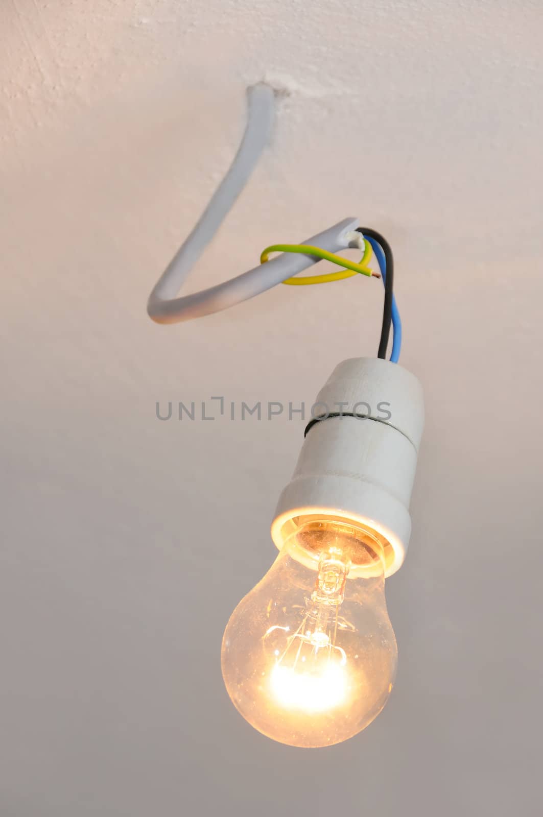 A glowing light bulb hanging on a cable, retro