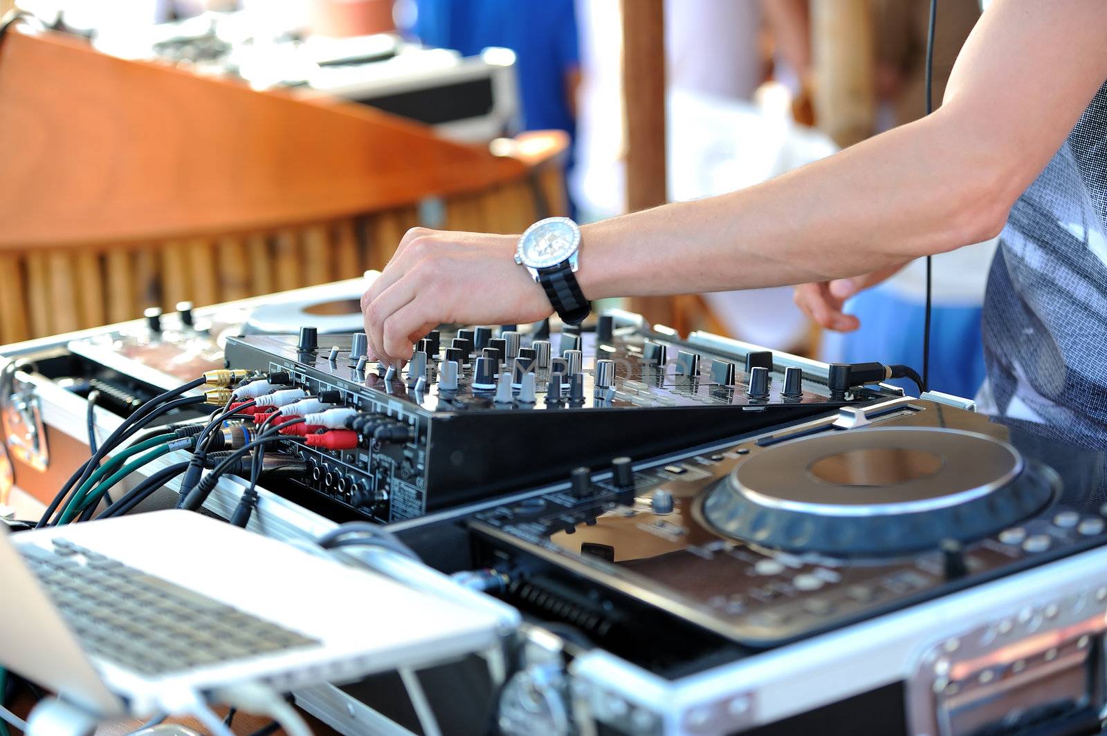 A detail of dj who is mixing the track on the beach party