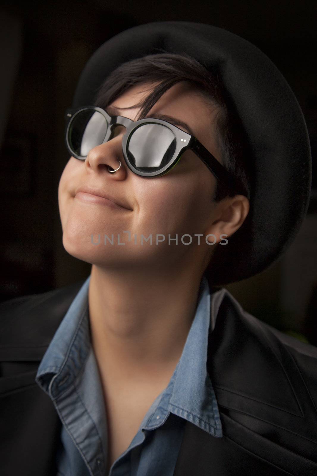 Ethnic Mixed Girl Wearing Sunglasses Against a Dark Background.