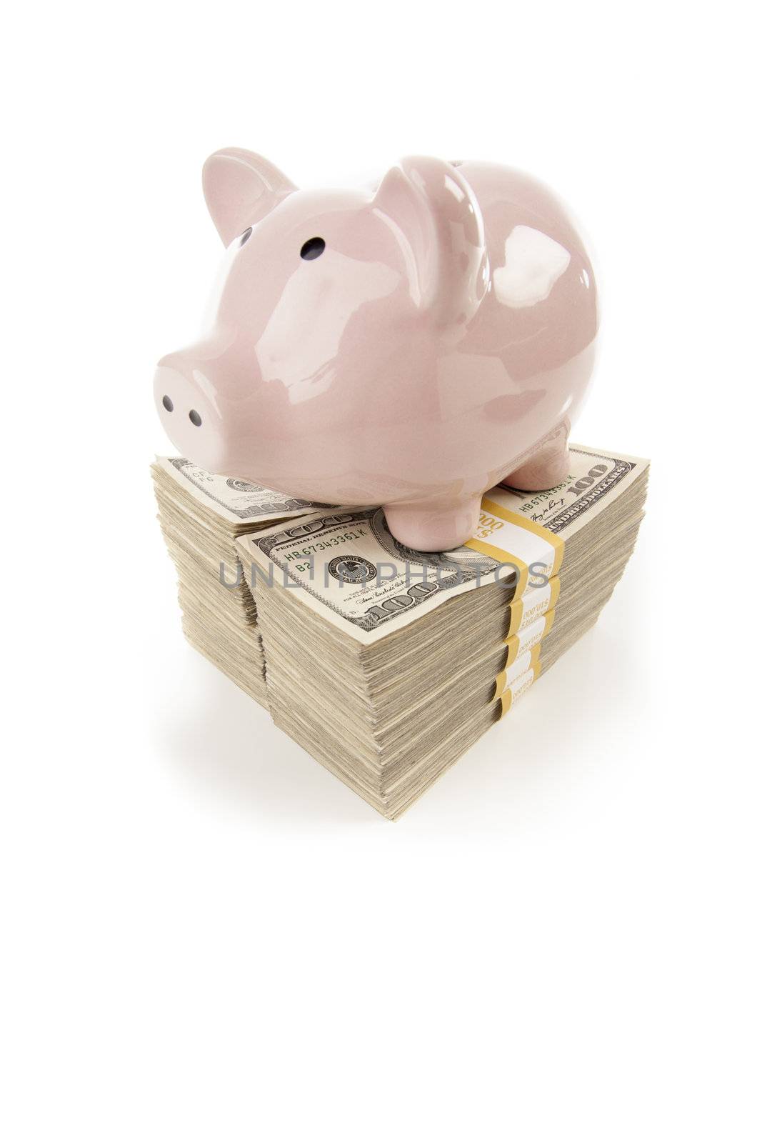 Pink Piggy Bank Standing on Stacks of Hundreds of Dollars Isolated on a White Background.