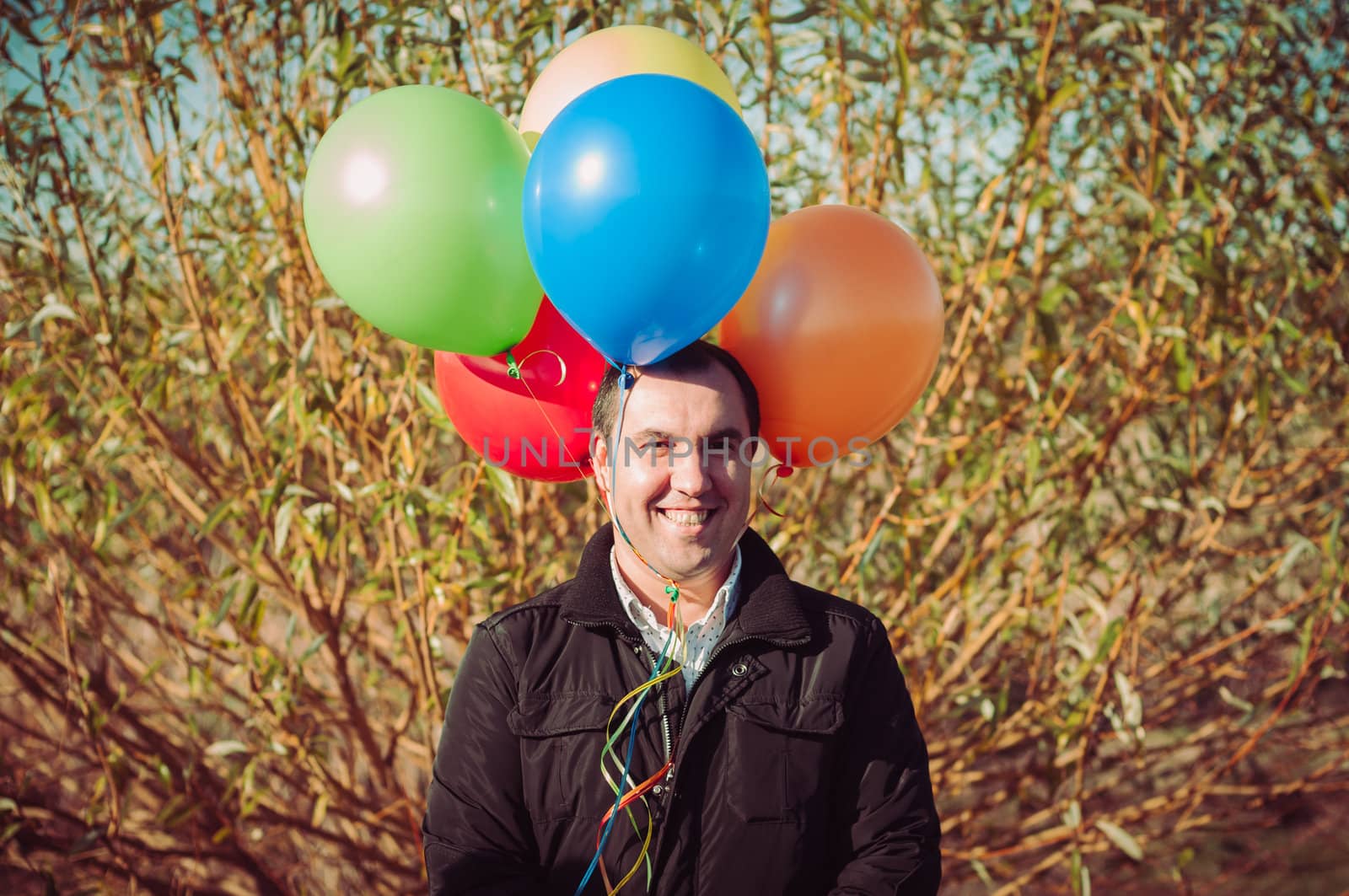 Young man with lot of balloons outdoor