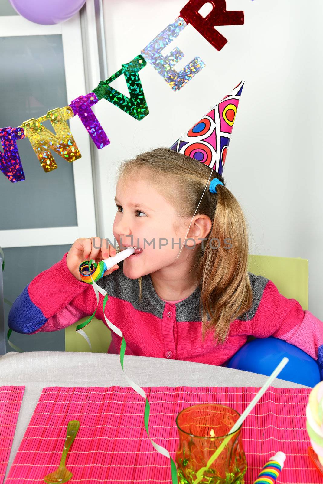 Happy little girl how have fun in a birthday party 