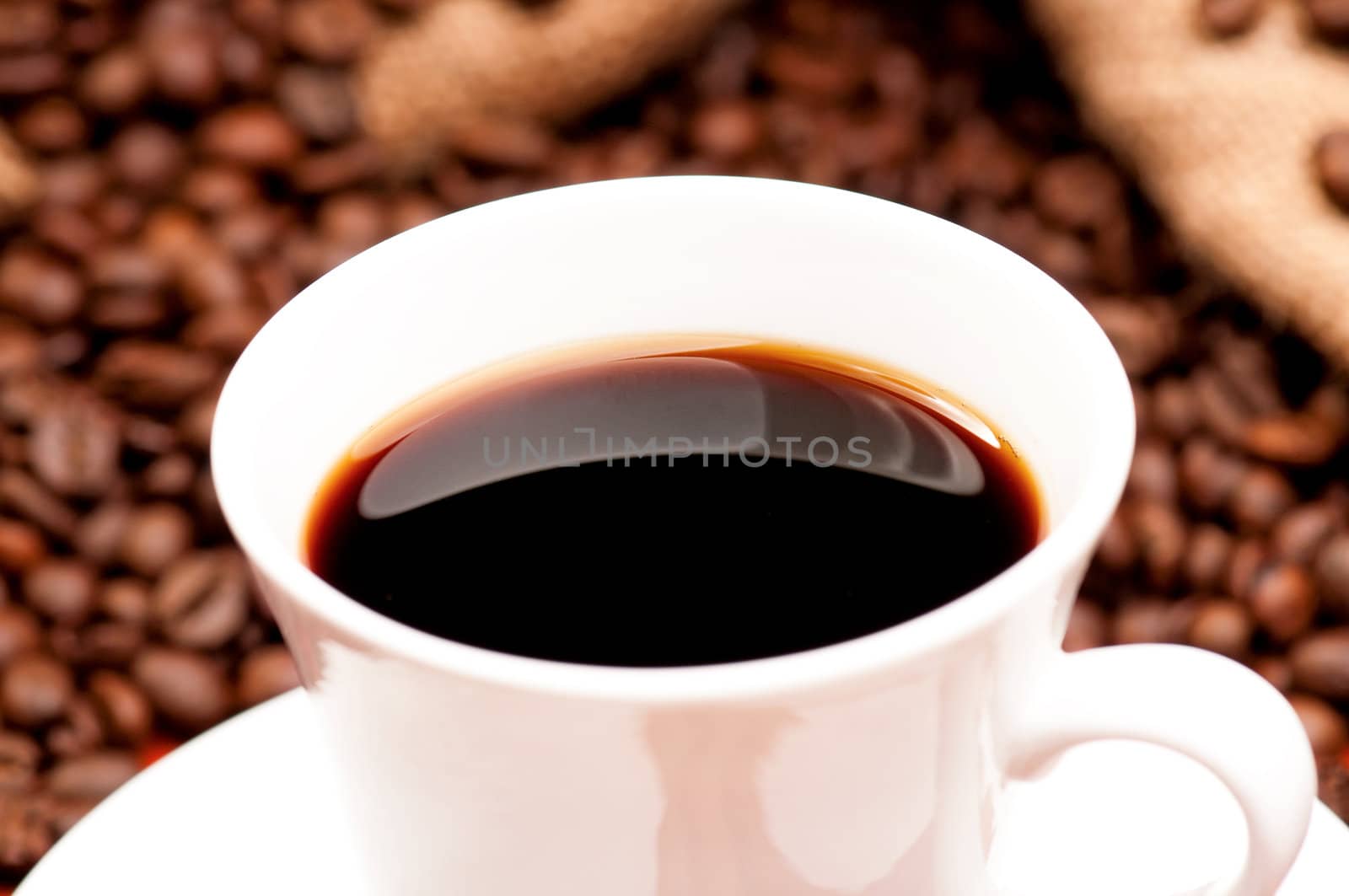 Close-up cup of coffee with coffee beans