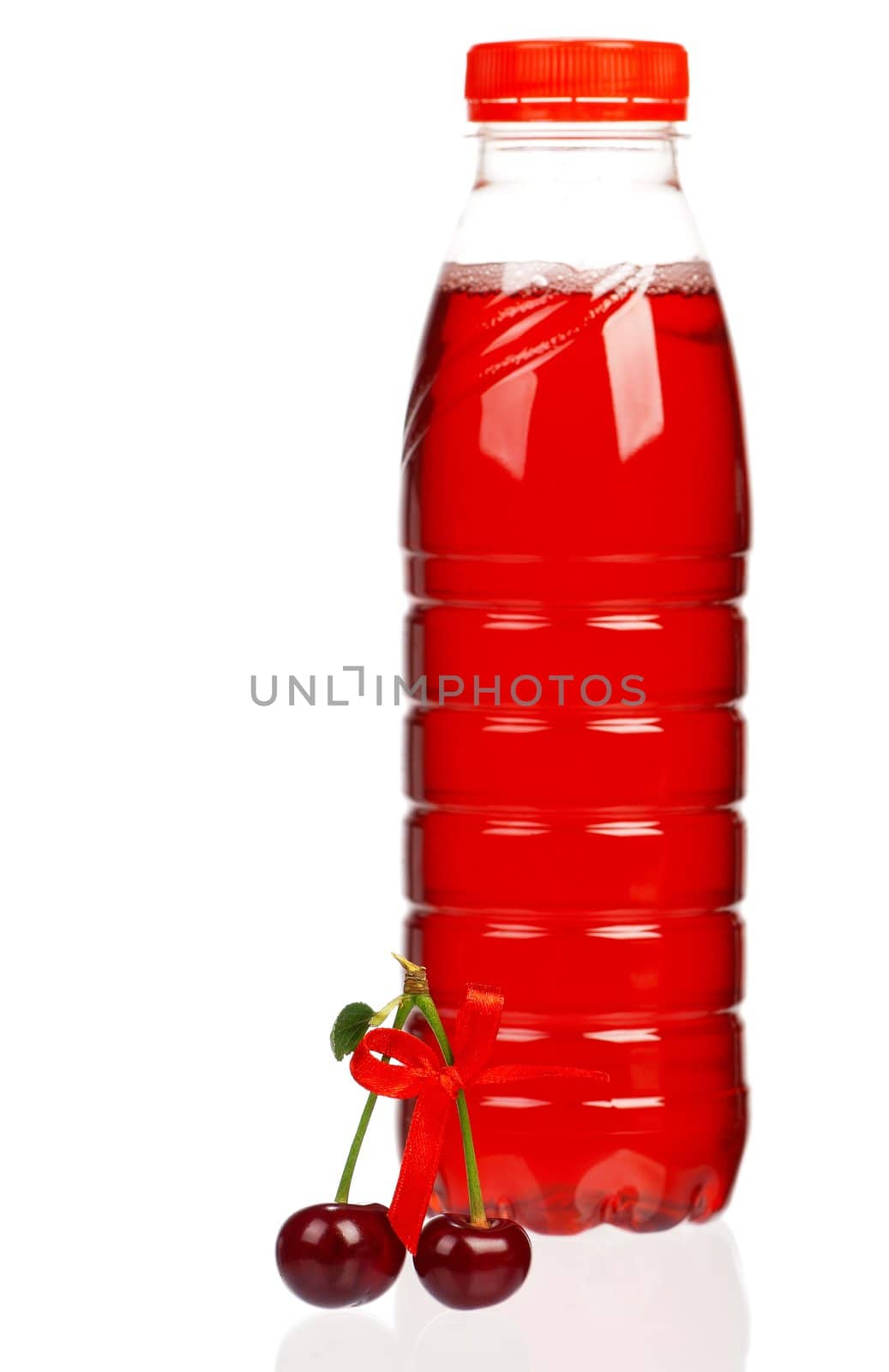 Sweet cherries and bottled juice on a white background