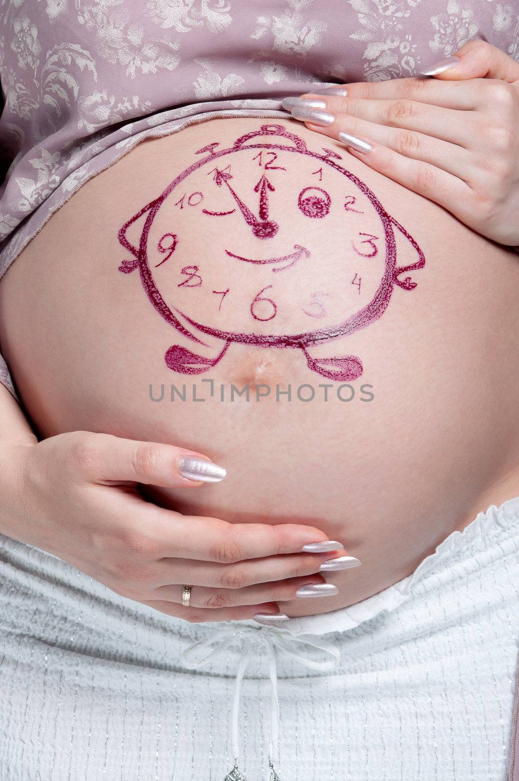 Tummy of pregnant woman with funny drawing over white background