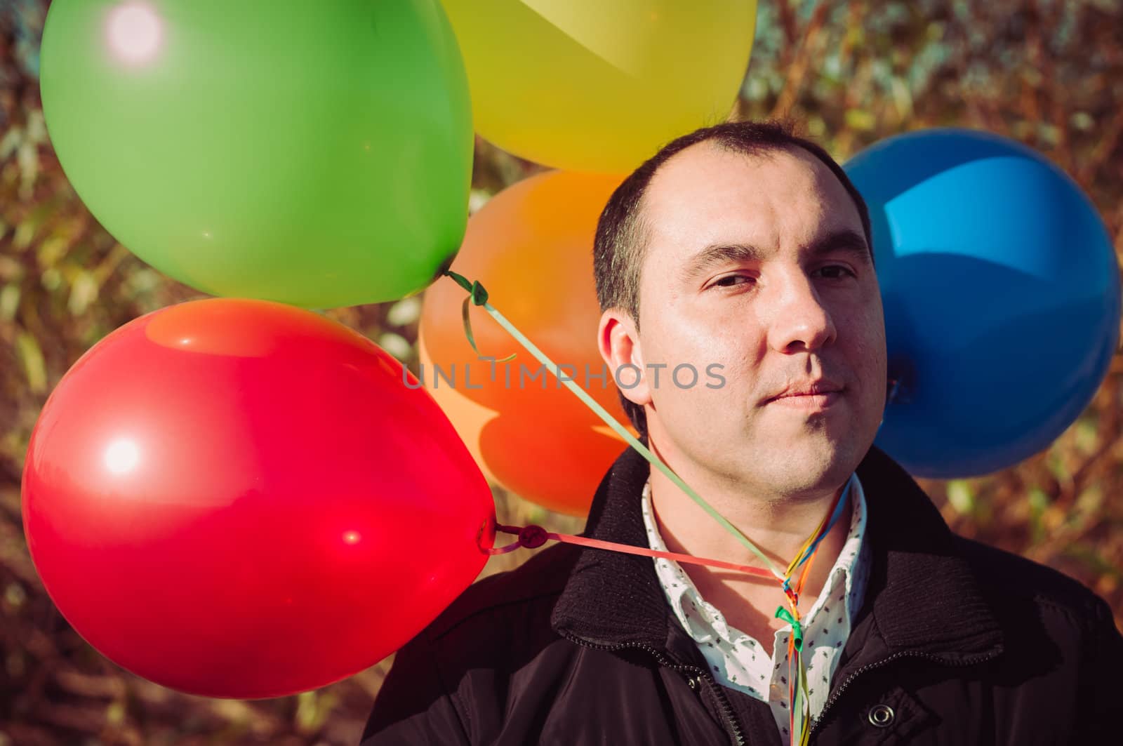 Young man with lot of balloons outdoor