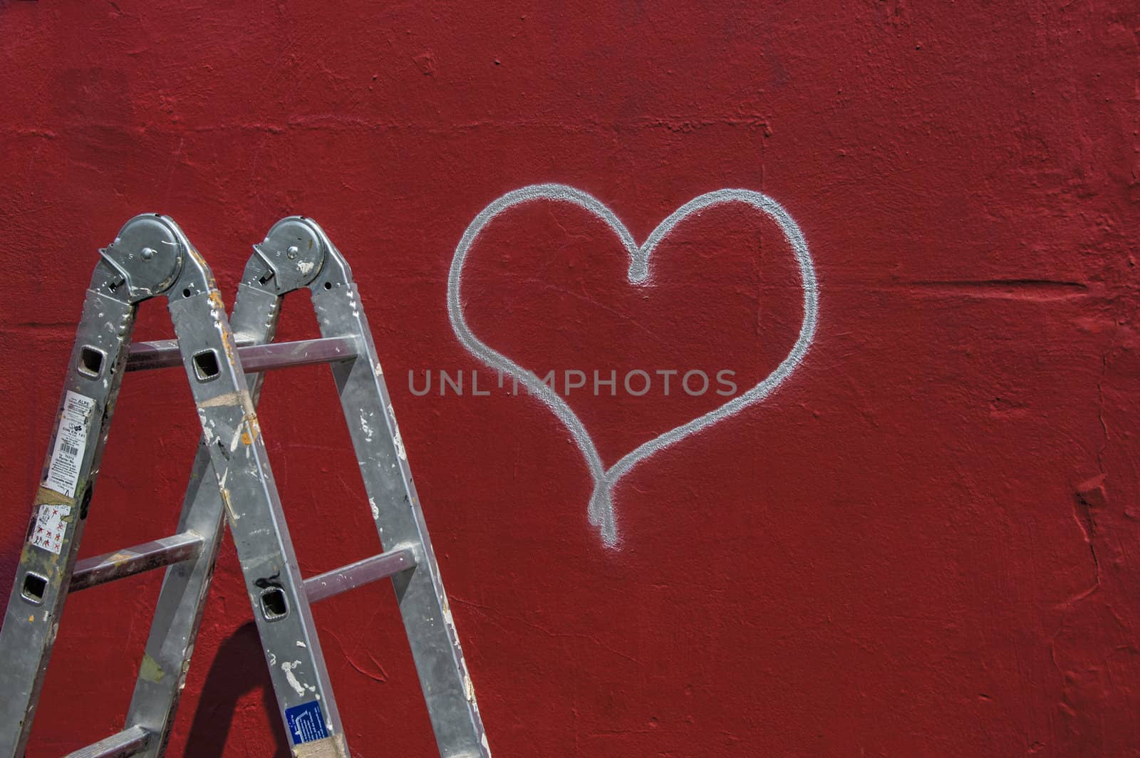 Heart graffiti on a red wall with ladder