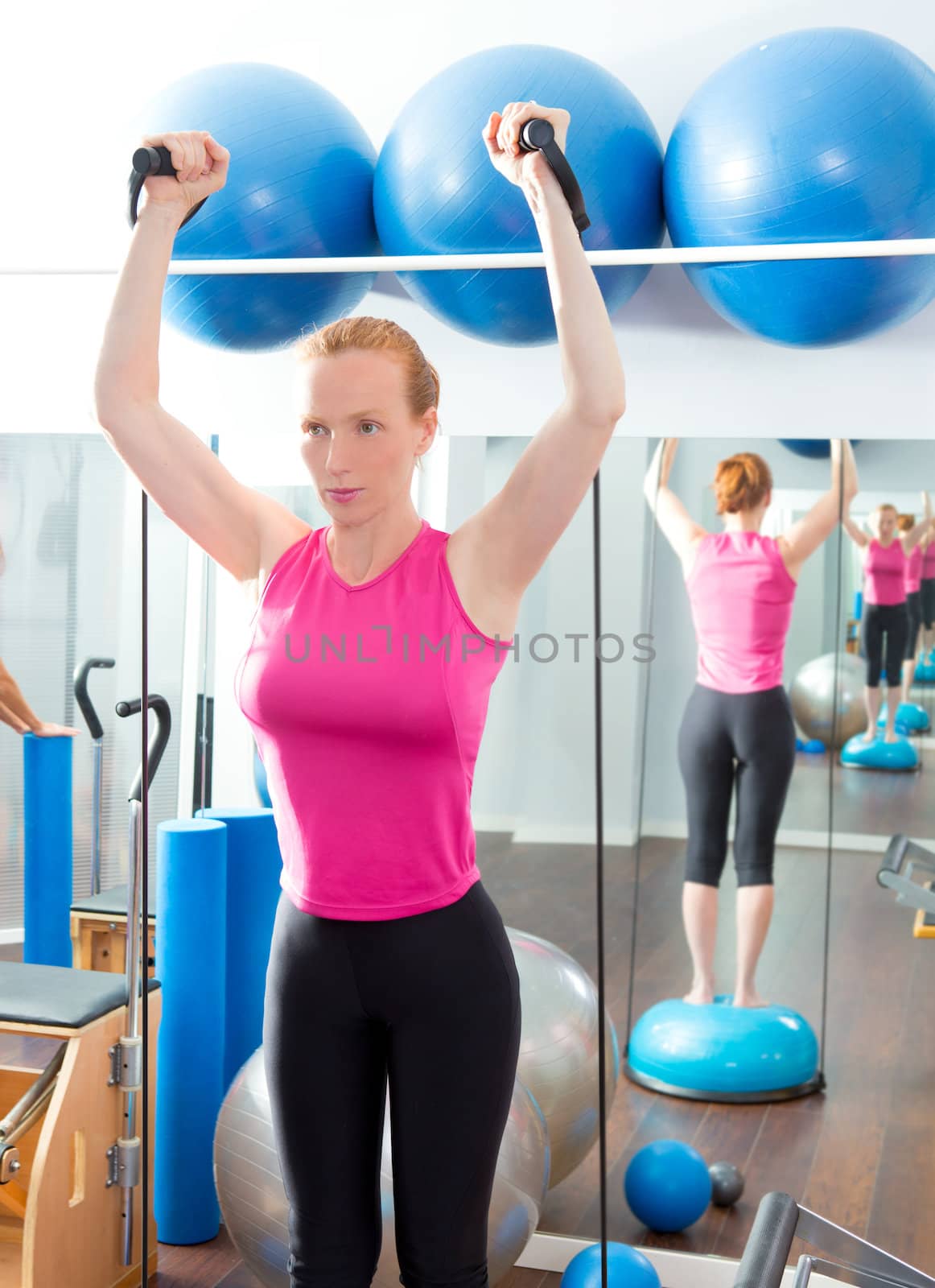 Bosu ball for fitness redhead woman in aerobics gym