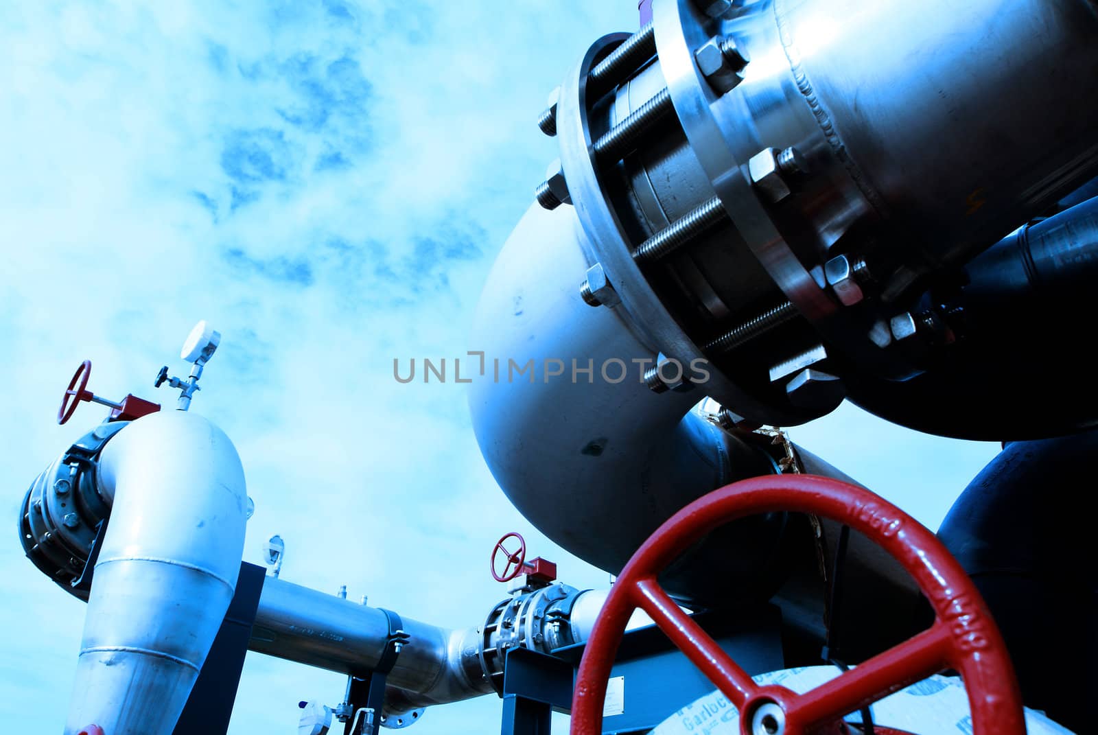 Industrial zone, Steel pipelines and valves against blue sky