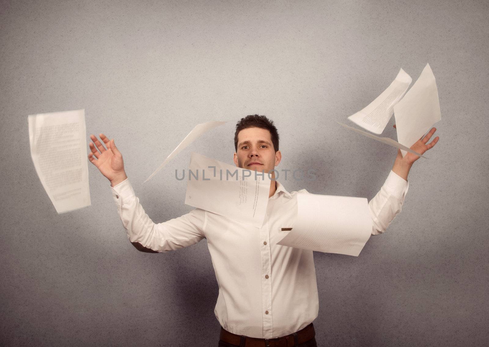 Young businessman throwing away his papers 
