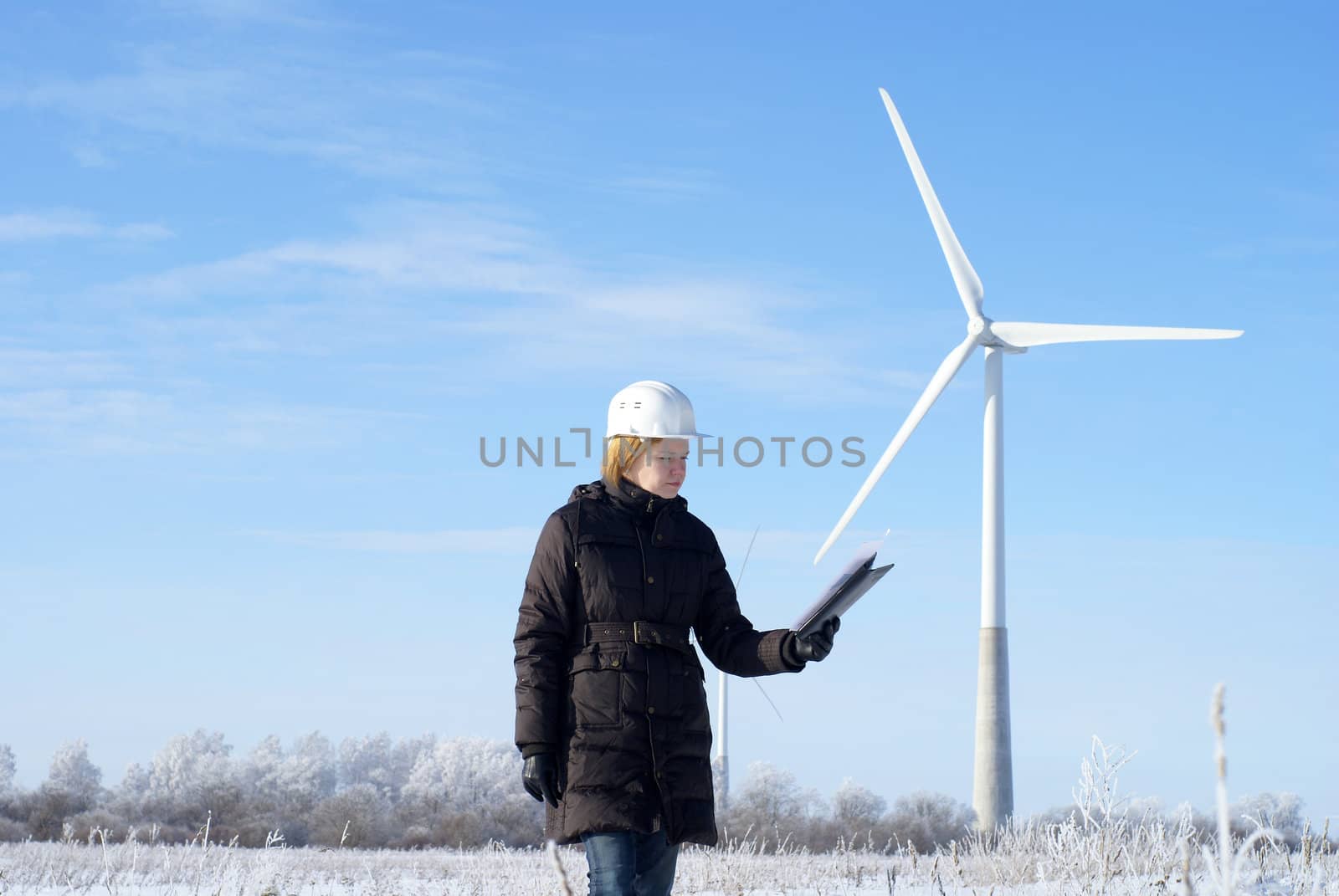 engineer or architect with white safety hat and wind turbines on background