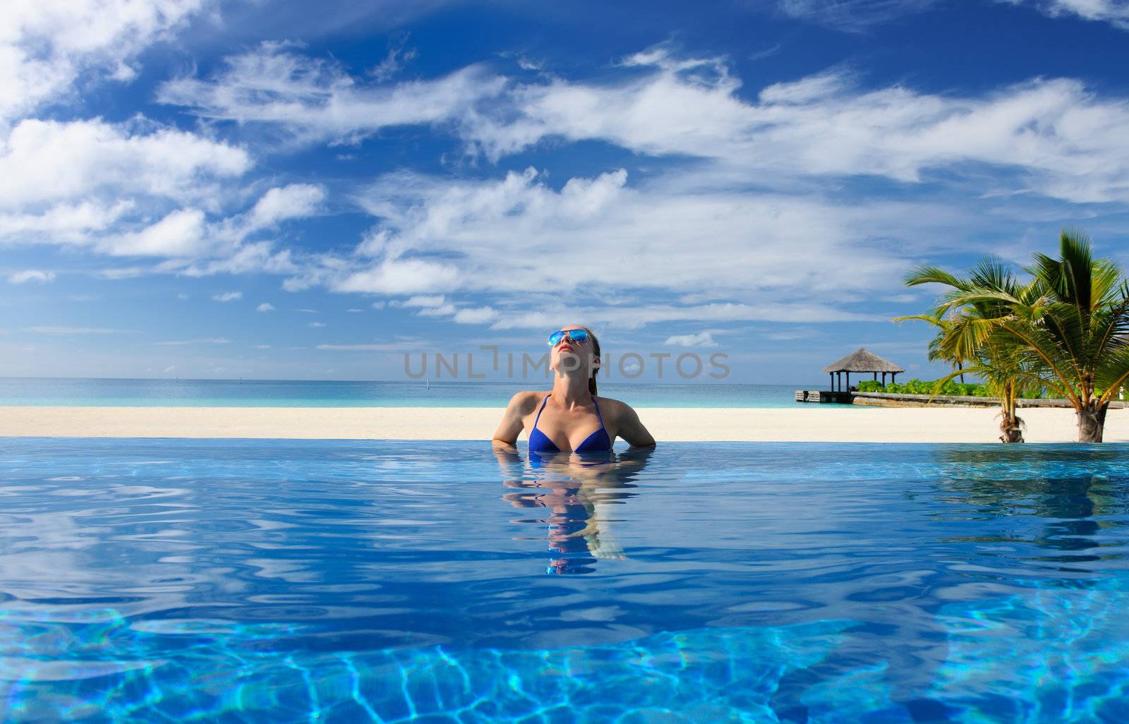 Woman in hat relaxing at the pool 