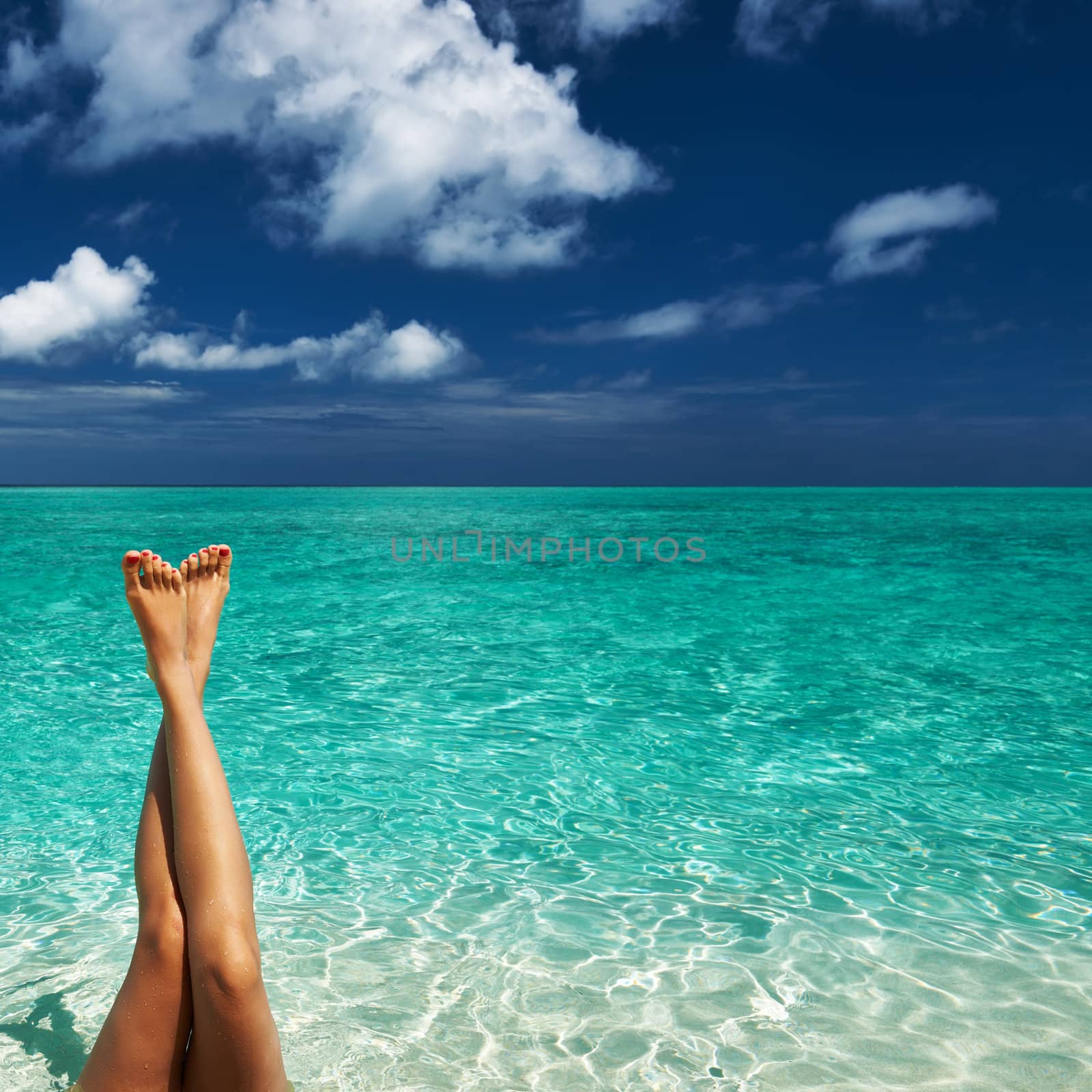 Woman's beautiful legs at beach 